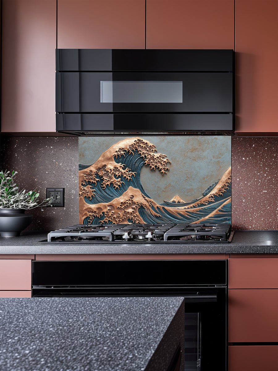 Tempered glass kitchen backsplash featuring a highly realistic 3D faux metal relief design of the Great Wave off Kanagawa, showcasing a striking contrast between deep blue water textures and embossed copper wave crests, installed behind a modern stainless steel stove.