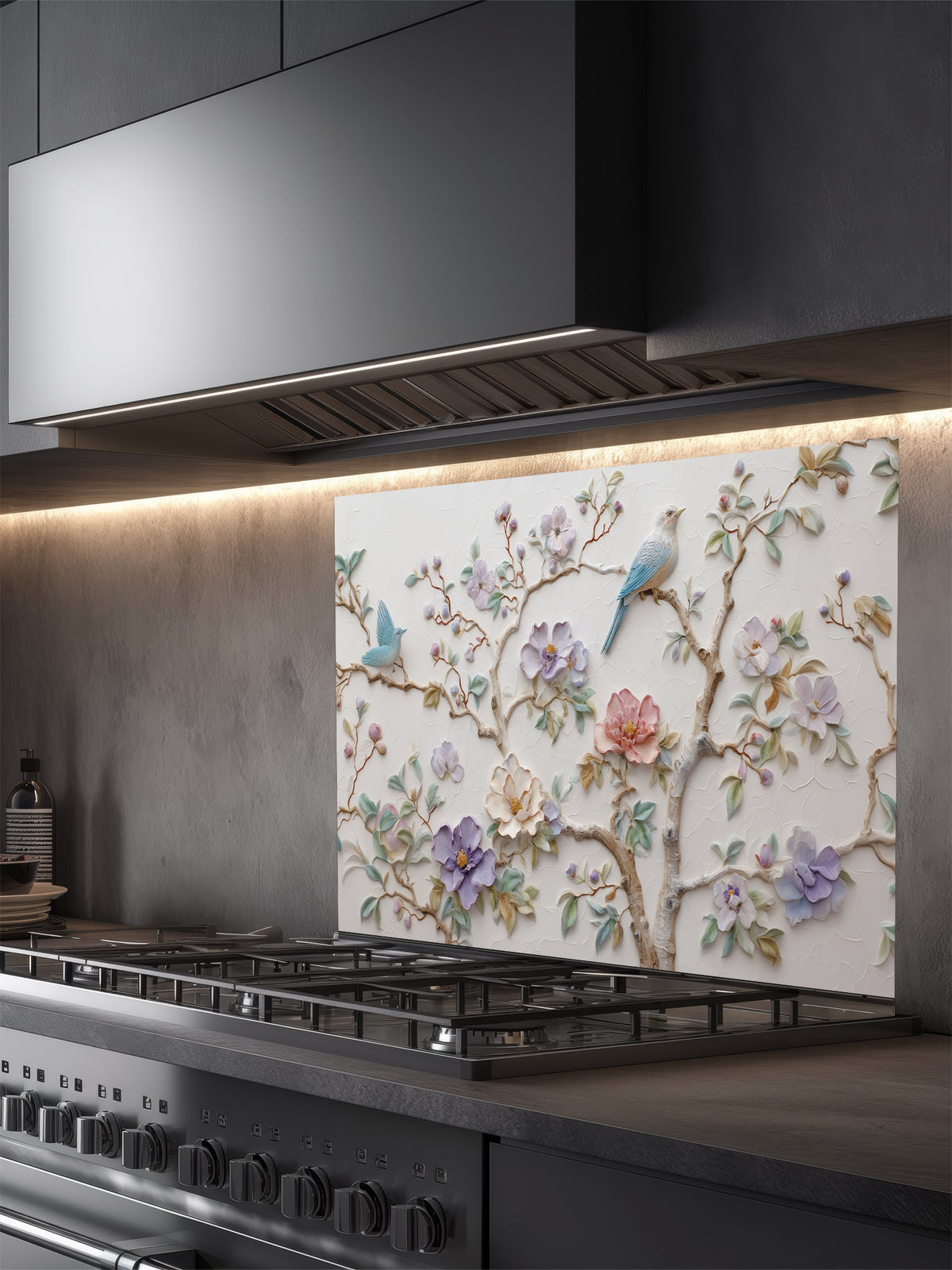 Tempered glass kitchen backsplash featuring a highly realistic 3D illusion of bas-relief plaster art with pastel blooming flowers and light blue birds perched on branches against a white textured background, installed behind a modern stainless steel stove.