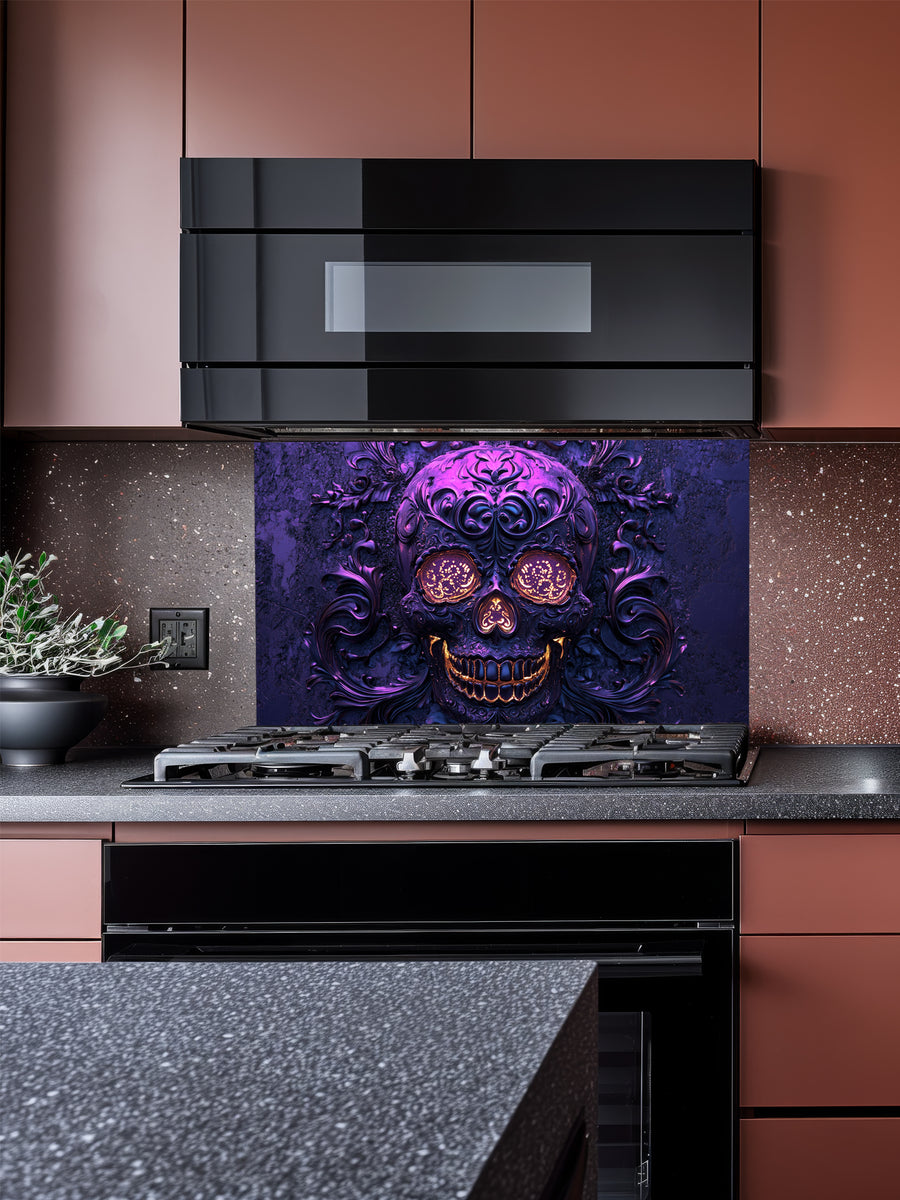 Tempered glass kitchen backsplash featuring a highly realistic 3D illusion of an embossed, intricately carved gothic skull with glowing gold eyes and teeth, surrounded by dark purple baroque filigree swirls, installed behind a modern black stove.
