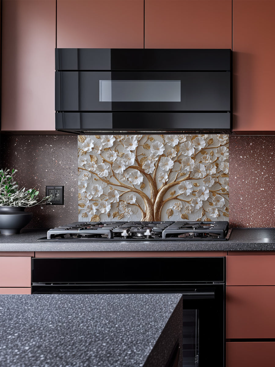 Faux 3D sculpted relief of a floral tree with pearl-white blossoms and heavy molten gold branches on a textured champagne background, UV printed on a smooth tempered glass kitchen backsplash.