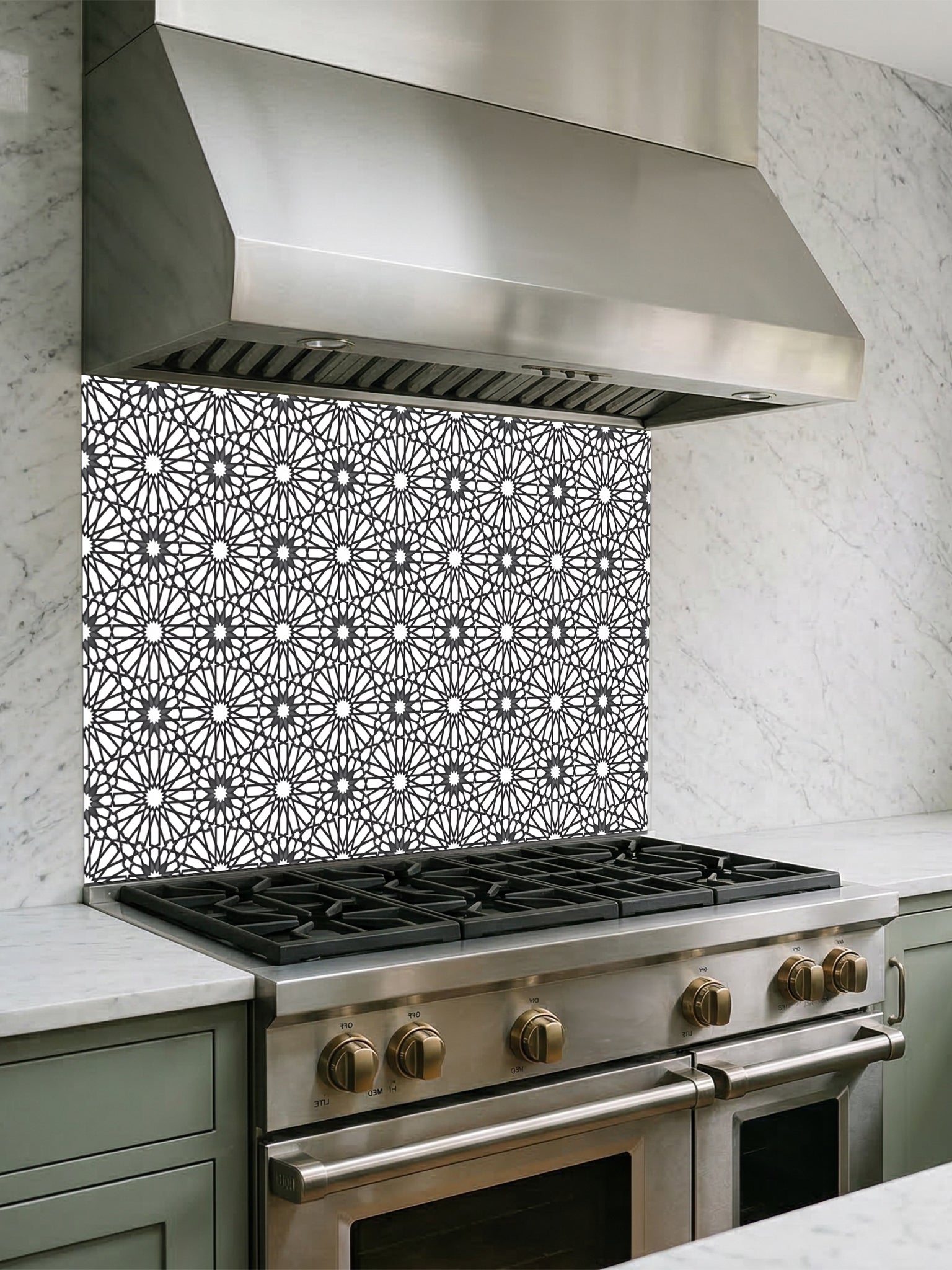 A modern minimalist kitchen featuring a tempered glass backsplash with a crisp black and white Moroccan geometric star pattern, installed behind a sleek stainless steel stove.