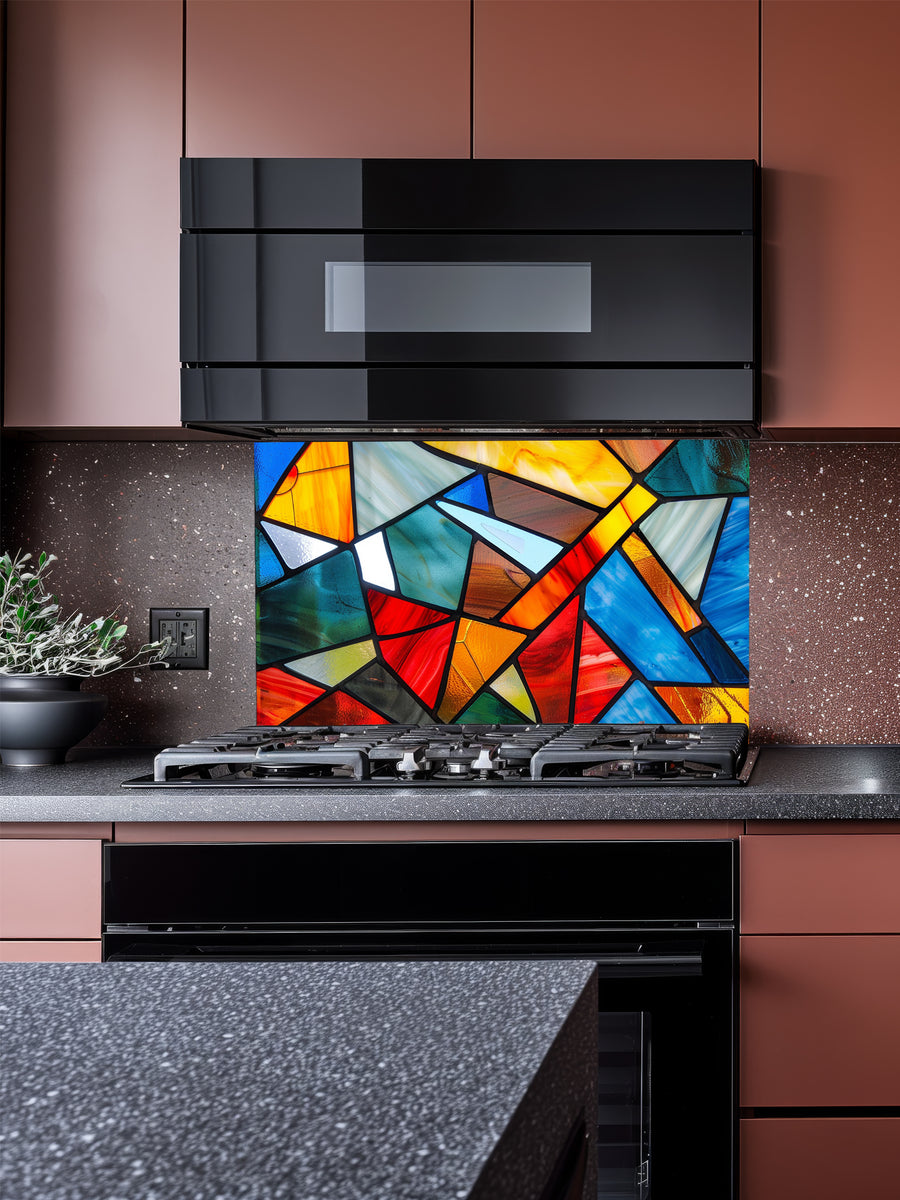 Tempered glass kitchen backsplash featuring a highly realistic illusion of abstract geometric stained glass with asymmetrical shards in vibrant, luminous shades of red, blue, yellow, and teal outlined by dark faux lead lines, installed behind a modern black stove.