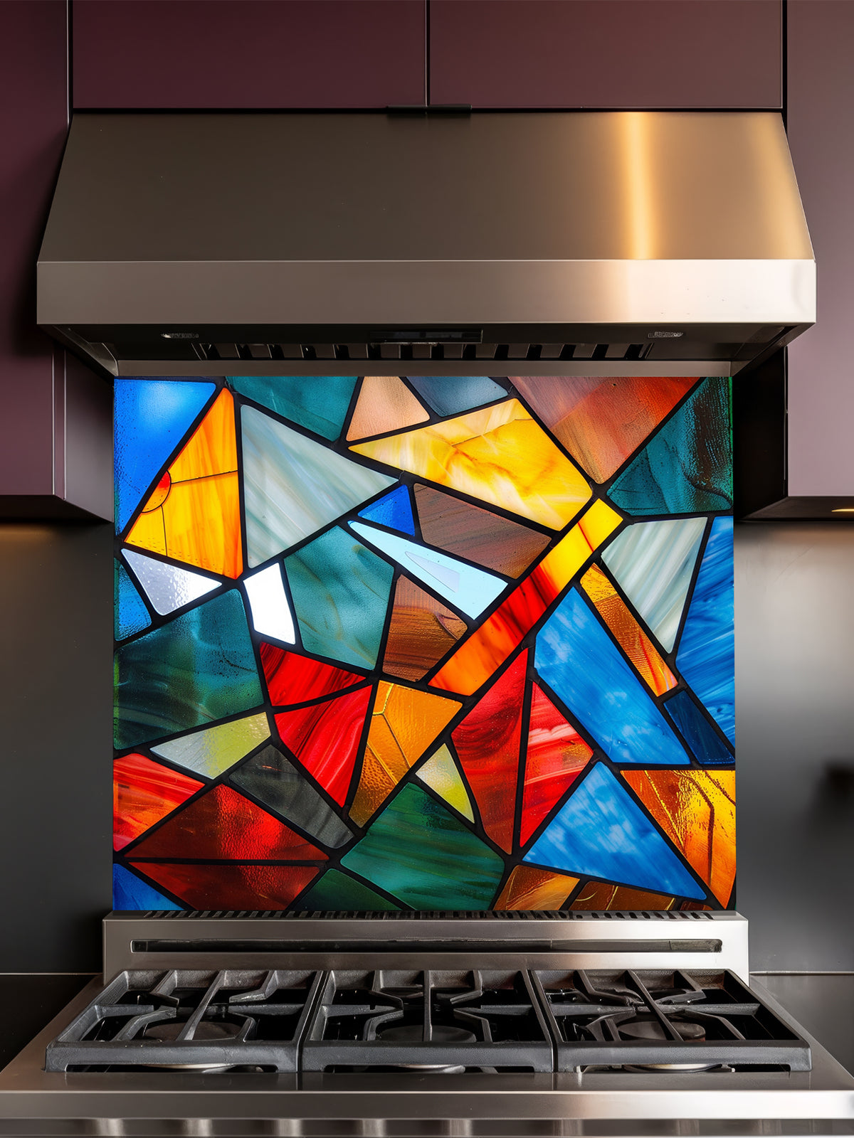 Tempered glass kitchen backsplash featuring a highly realistic illusion of abstract geometric stained glass with asymmetrical shards in vibrant, luminous shades of red, blue, yellow, and teal outlined by dark faux lead lines, installed behind a modern black stove.