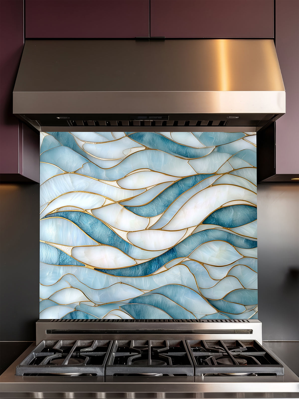 Tempered glass kitchen backsplash featuring a calming modern abstract wave design in faux stained glass with blue, teal, and pearlescent white sections separated by elegant gold lines, installed behind a modern stainless steel stove.