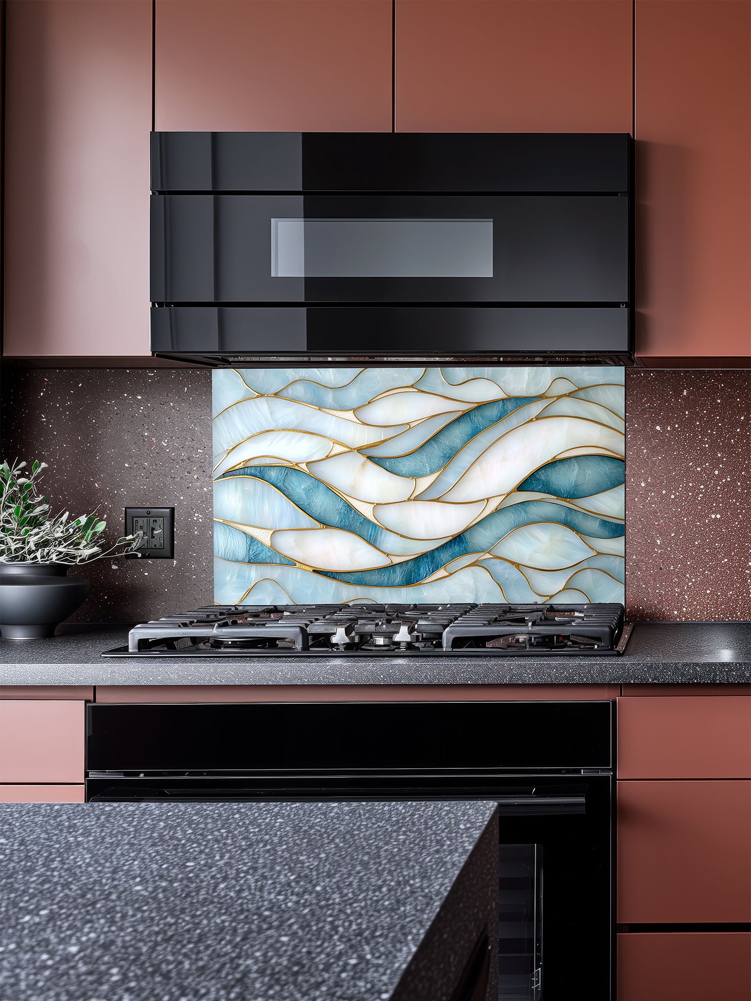 Tempered glass kitchen backsplash featuring a calming modern abstract wave design in faux stained glass with blue, teal, and pearlescent white sections separated by elegant gold lines, installed behind a modern stainless steel stove.