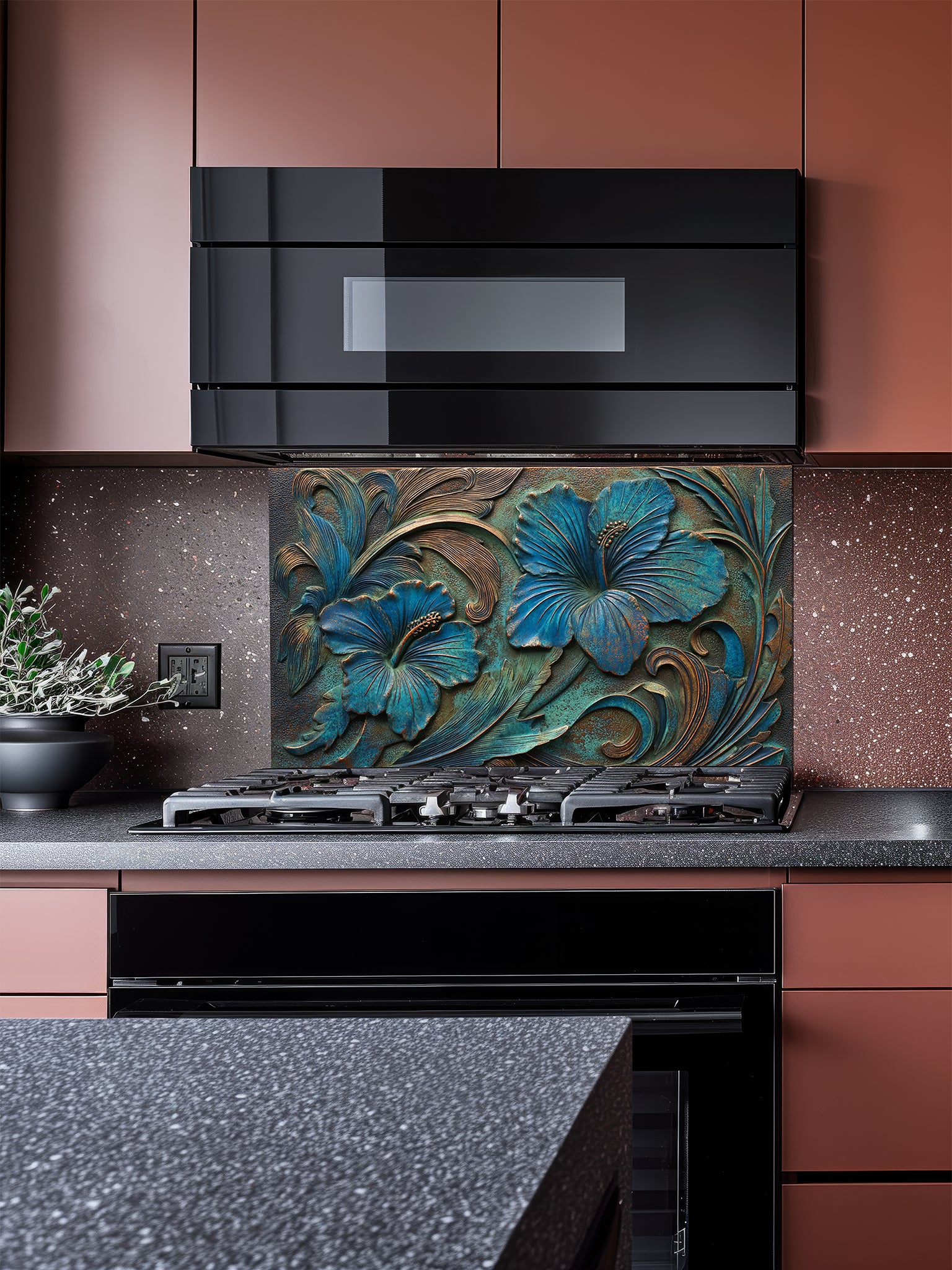 Tempered glass kitchen backsplash featuring a highly realistic 3D faux metal relief design of large tropical hibiscus flowers with a rich teal patina and antique copper accents over a dark textured background, installed behind a modern stainless steel stove.
