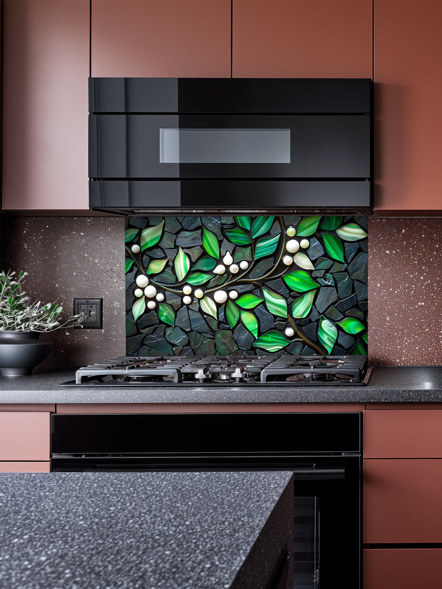 Tempered glass kitchen backsplash featuring a highly realistic 3D illusion of a stone mosaic showcasing vibrant emerald green agate-like leaves and white pearl berries on a glowing golden branch against a dark charcoal stone background, installed behind a modern black stove.