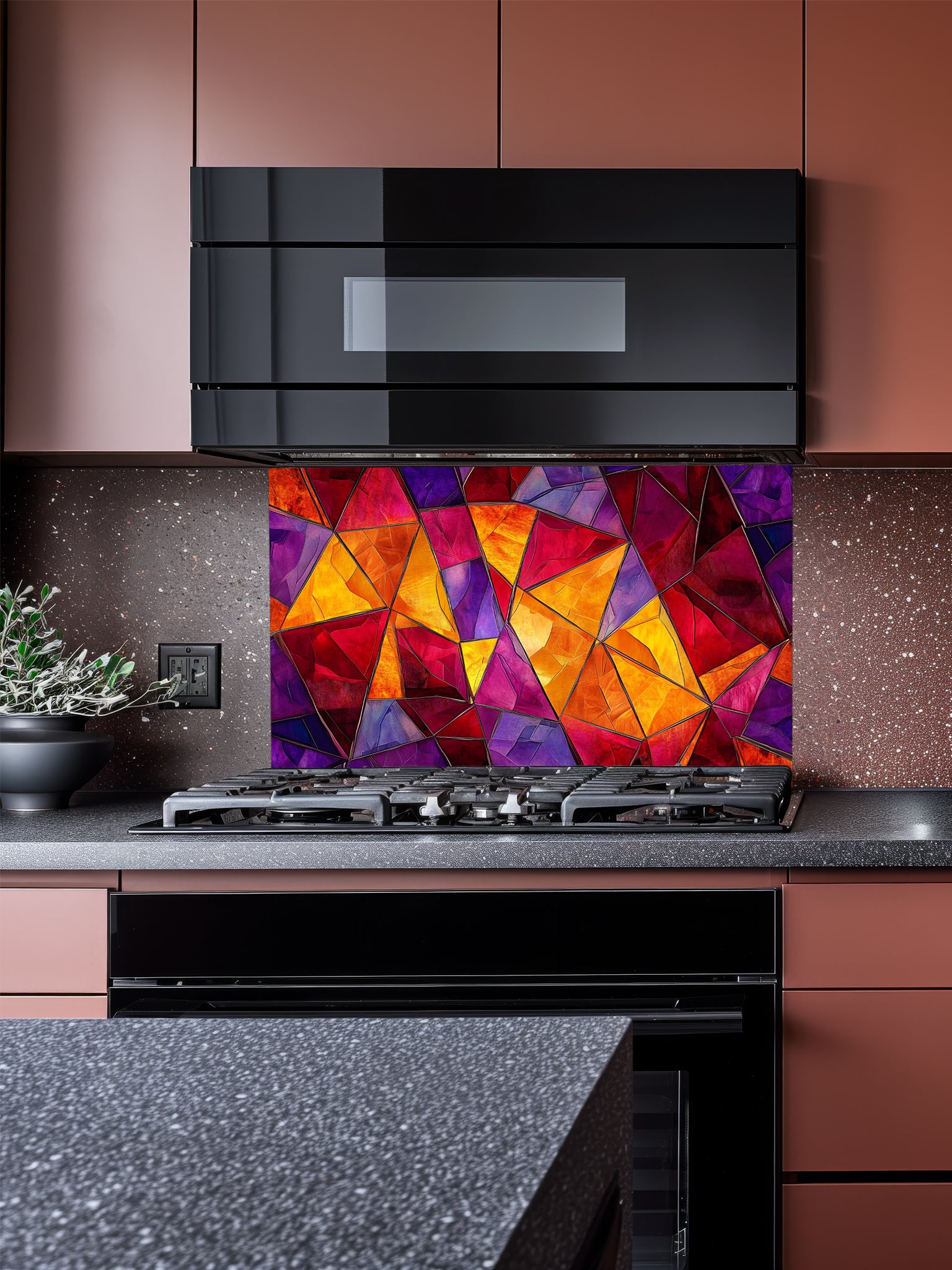 Tempered glass kitchen backsplash featuring a highly realistic illusion of abstract geometric stained glass with asymmetrical shards in vibrant, warm jewel tones of ruby red, magenta, amethyst, and amber, installed behind a modern black stove.