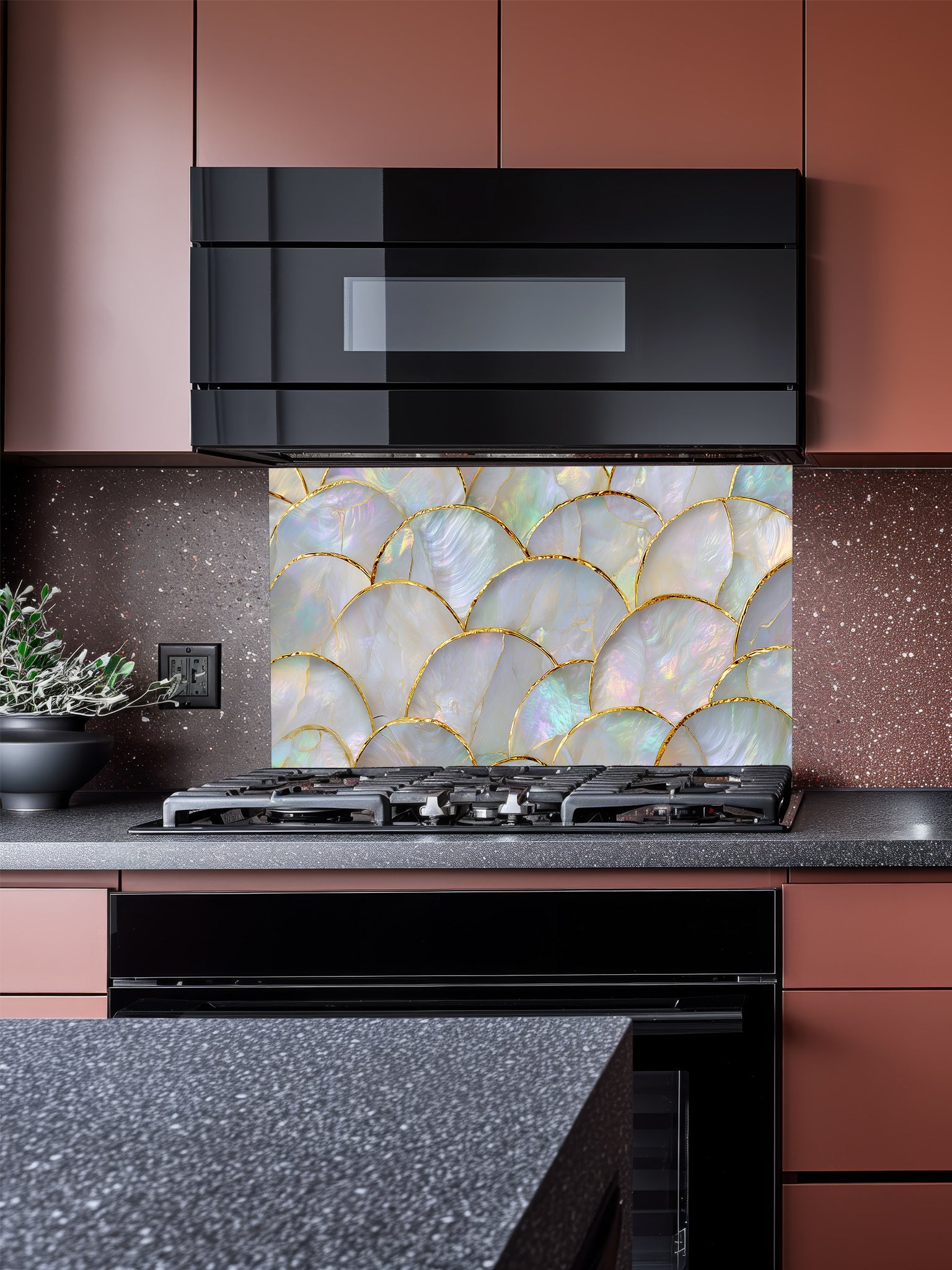 A luxurious kitchen featuring a tempered glass backsplash with an iridescent mother of pearl scallop pattern and gold accents, installed behind a modern stainless steel stove.