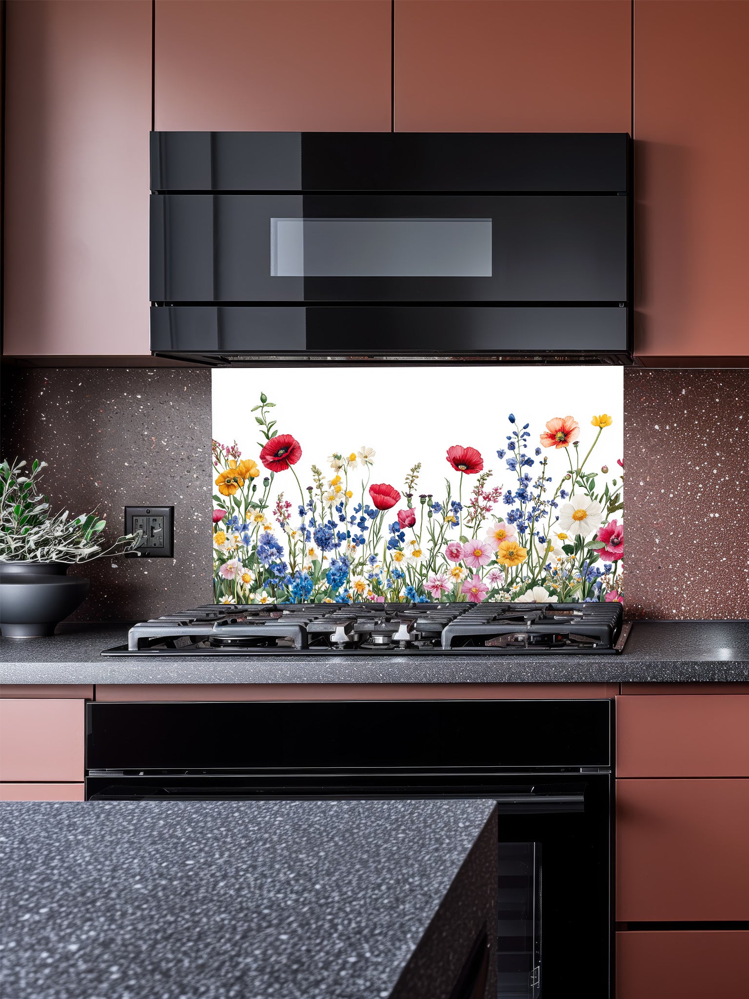 A bright kitchen featuring a tempered glass backsplash with a vibrant botanical illustration of a colorful wildflower meadow on a crisp white background, installed behind a modern stainless steel stove.