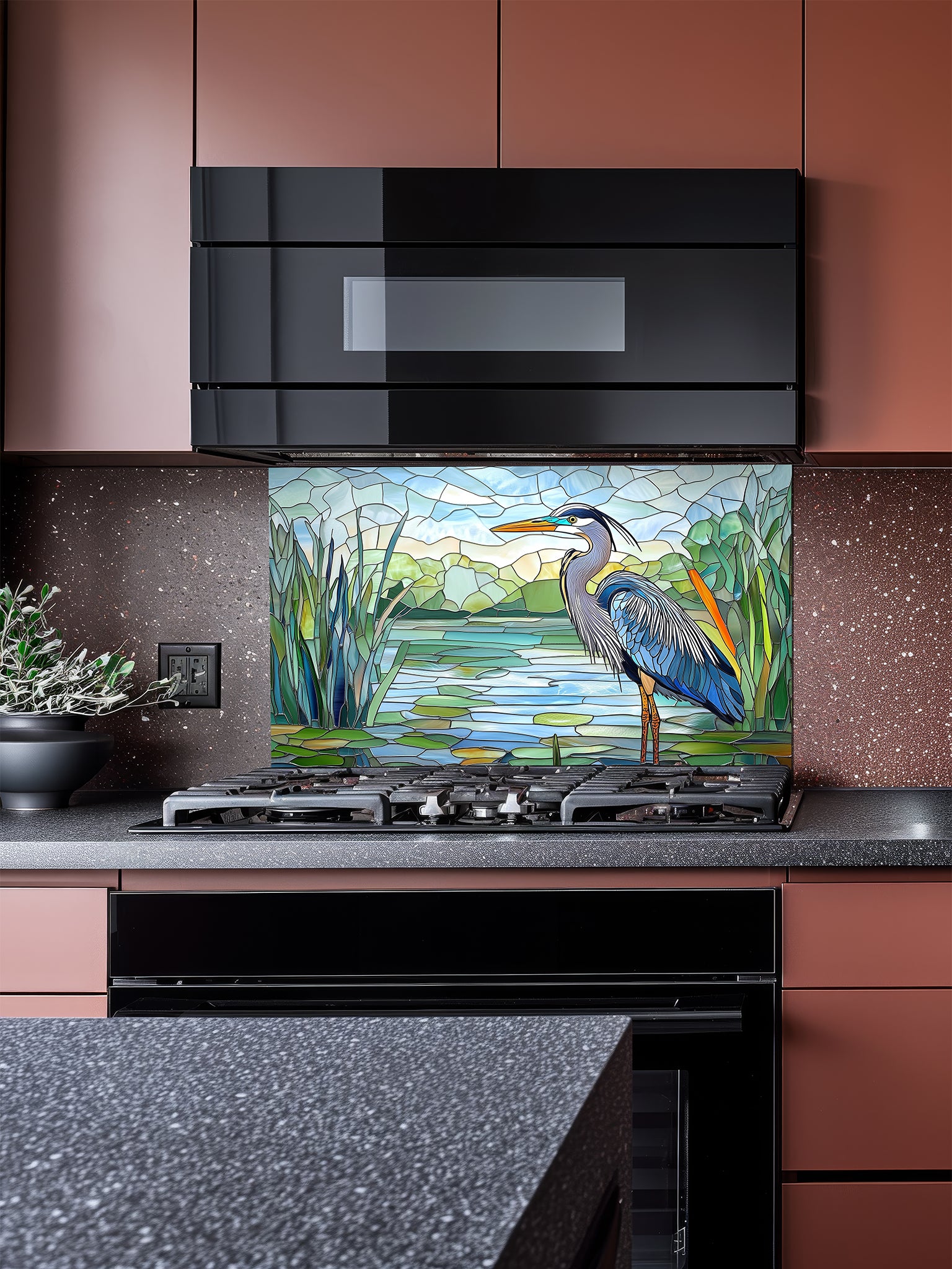 Tempered glass kitchen backsplash featuring a bright faux stained glass design of a majestic blue heron standing among lily pads against a clear blue sky and tranquil wetland, installed behind a modern stainless steel stove.