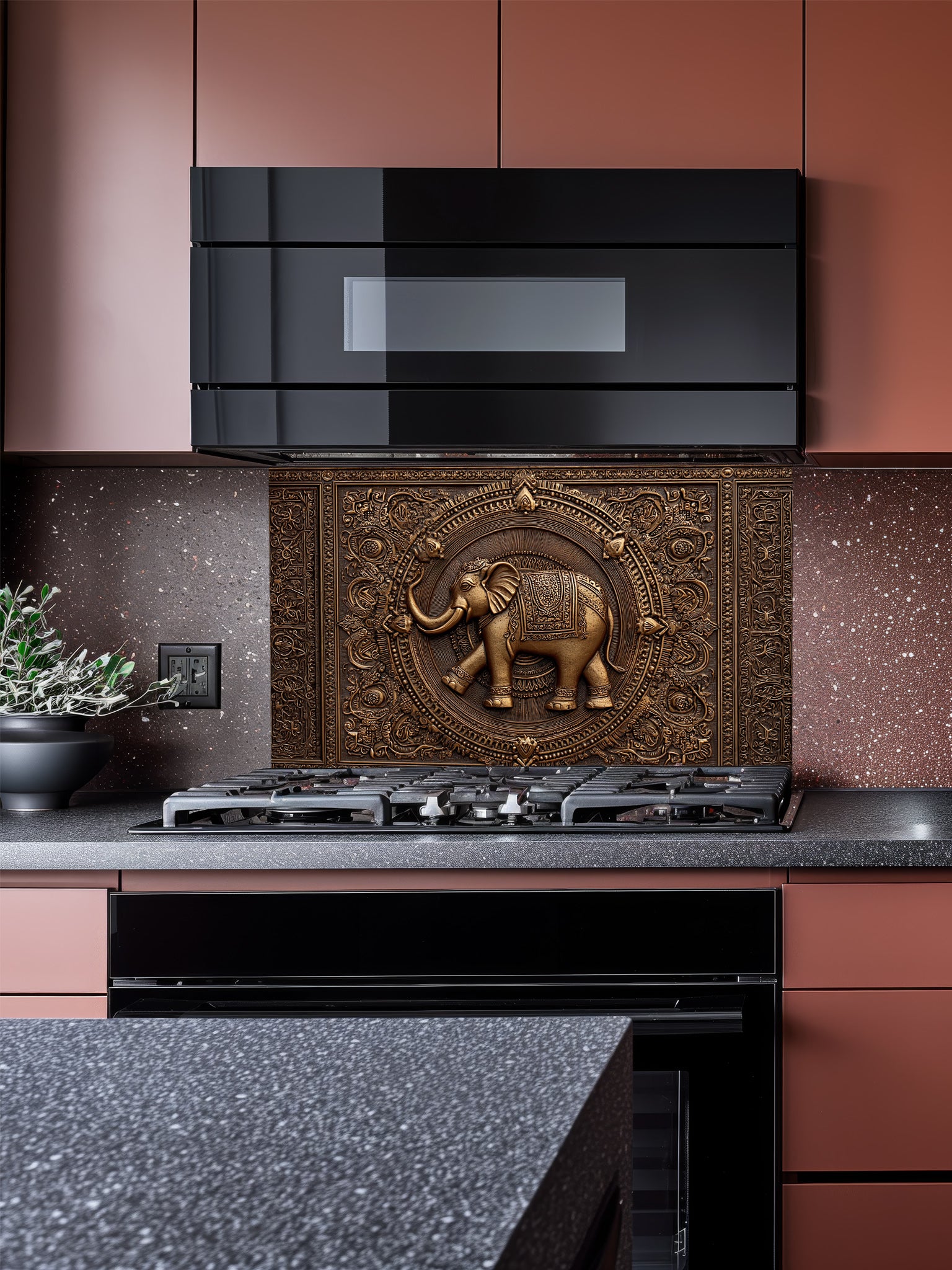 Faux 3D effect intricately carved bronze elephant and ornate mandala pattern, UV printed on a smooth tempered glass kitchen backsplash, installed behind a modern stove.