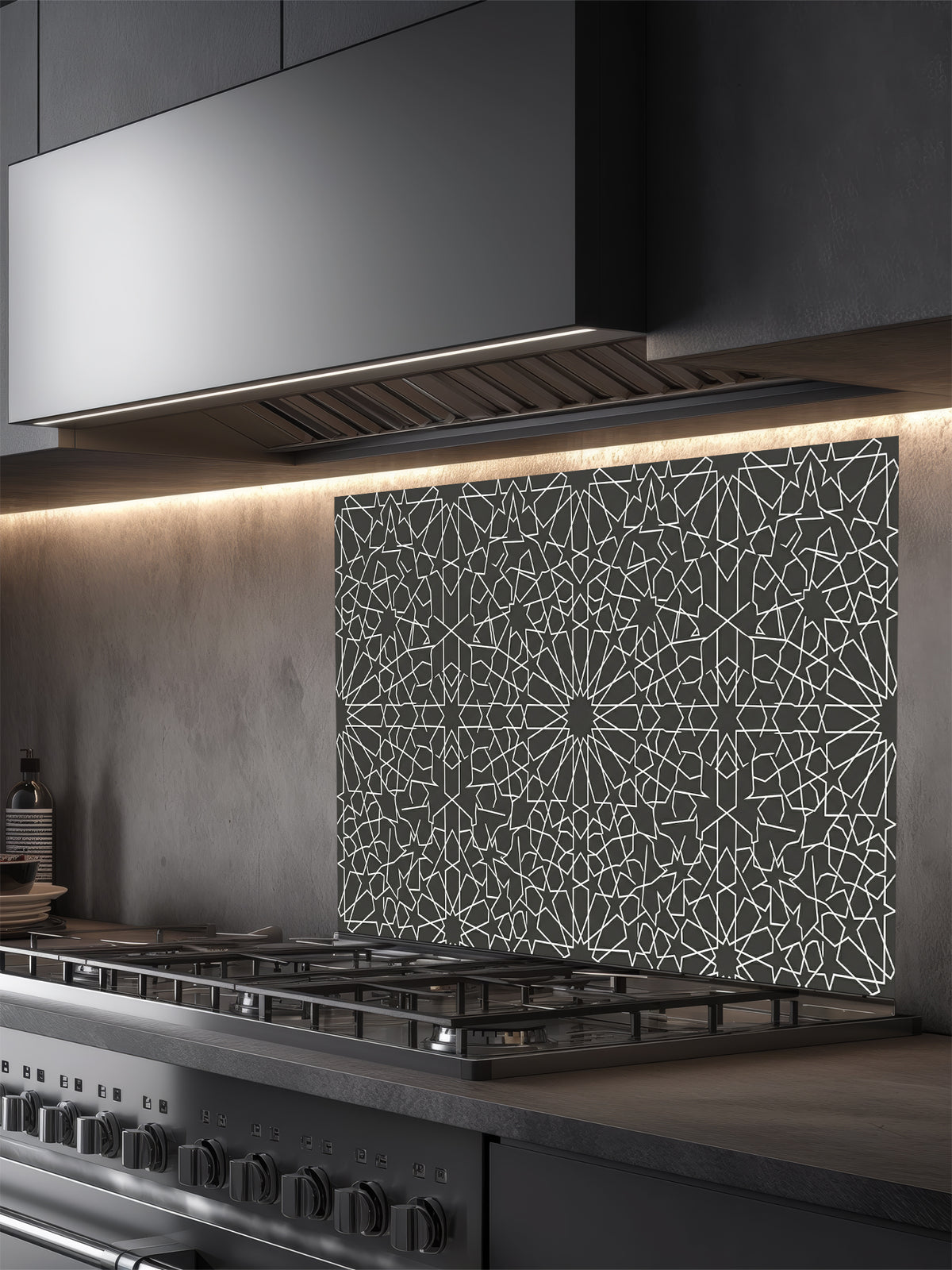 Modern kitchen with a decorative glass splashback behind a stove.