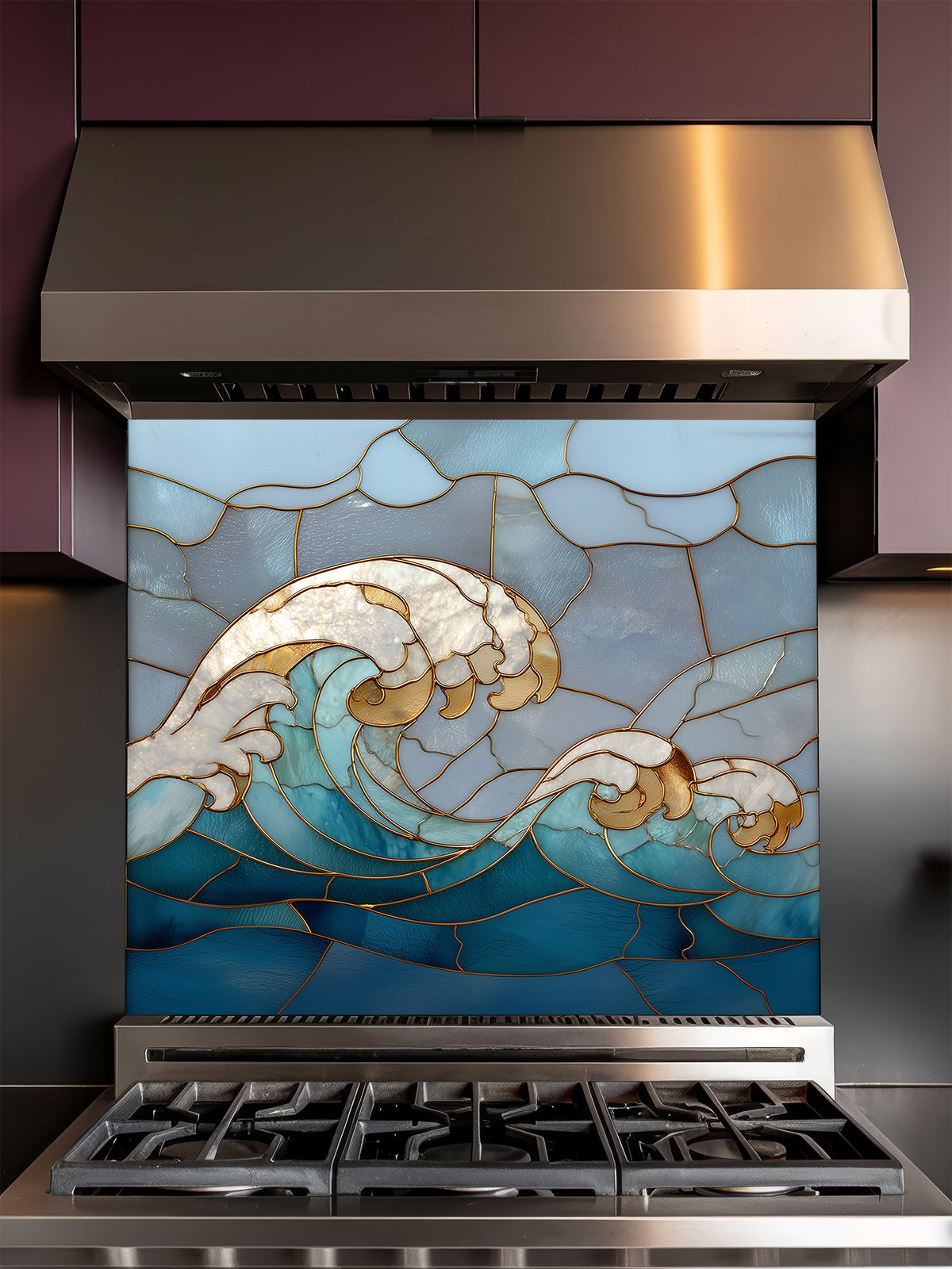 Tempered glass kitchen backsplash featuring a dramatic crashing ocean wave design in faux stained glass with deep blue water, white foam crests, and elegant gold outlines, installed behind a modern stainless steel stove.