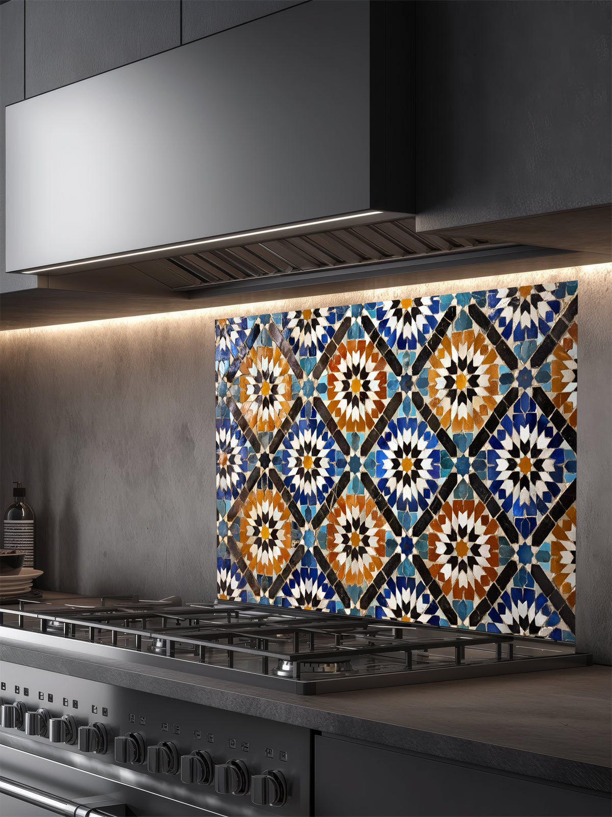 Decorative glass splashback with geometric pattern above a kitchen stove.