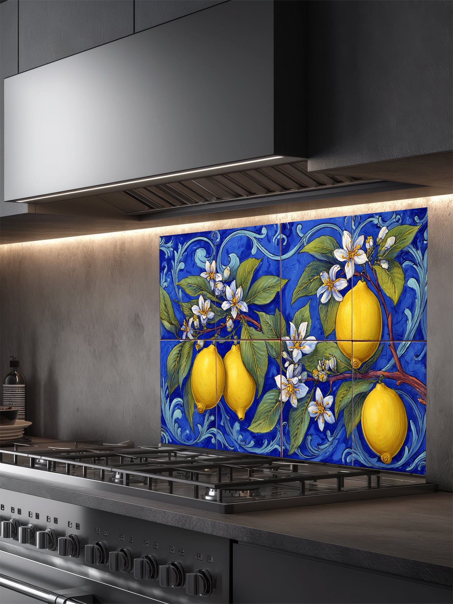 Tempered glass kitchen backsplash featuring a highly realistic illusion of traditional hand-painted Italian Majolica ceramic tiles, showcasing bright yellow lemons, white blossoms, and green leaves against a deep royal blue background with elegant scrollwork, installed behind a modern black stove.