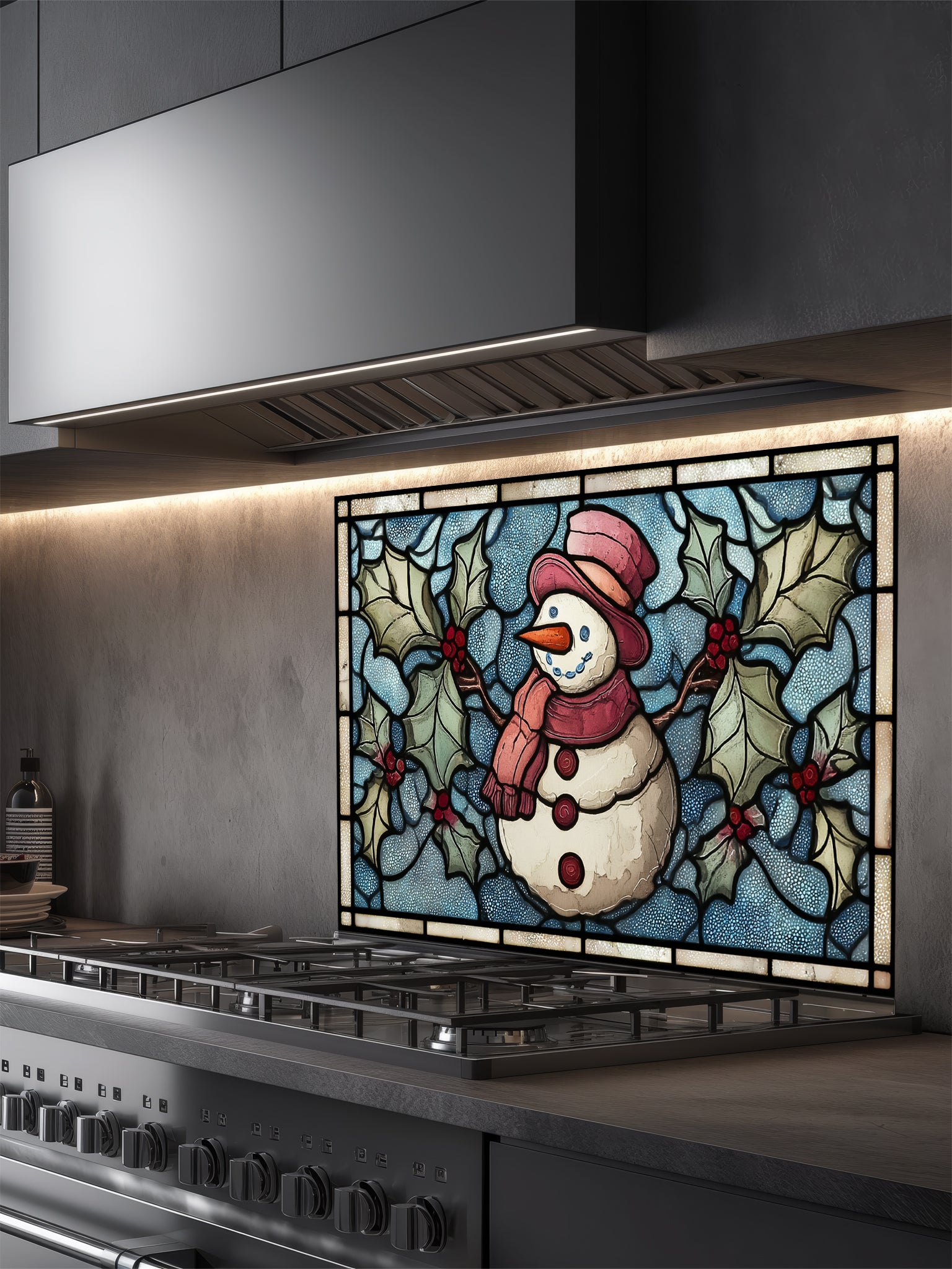 Tempered glass kitchen backsplash featuring a highly realistic 3D illusion of stained glass art showing a cheerful snowman with a red hat and scarf surrounded by green winter holly and red berries against a frosted icy blue background, installed behind a modern black stove.