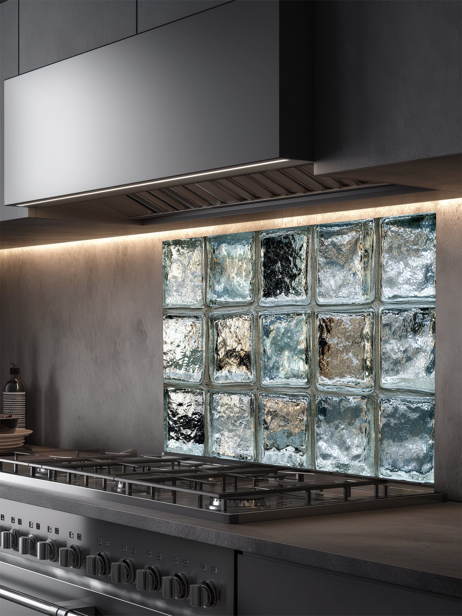 Tempered glass kitchen backsplash featuring a highly realistic 3D illusion of classic architectural clear glass blocks with authentic wavy, ice-like textures and sleek silver-grey reflections, installed behind a modern black stove.