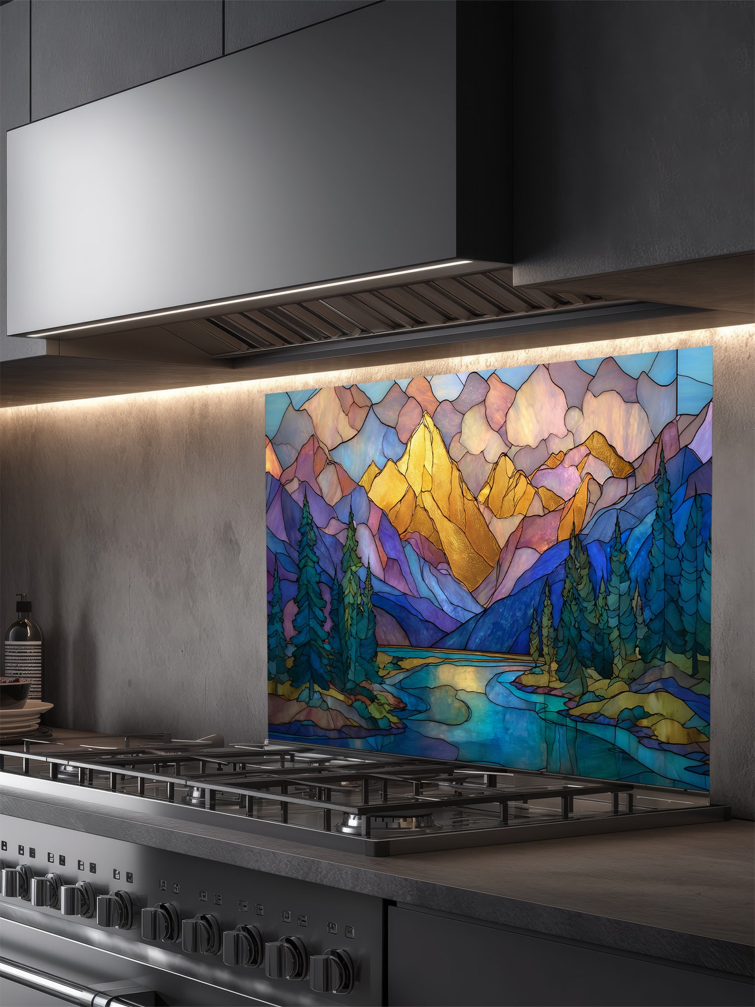 A cozy kitchen featuring a tempered glass backsplash with a beautiful stained glass effect landscape, showcasing majestic mountains, pine trees, and a winding river at sunset, installed behind a modern stainless steel stove.