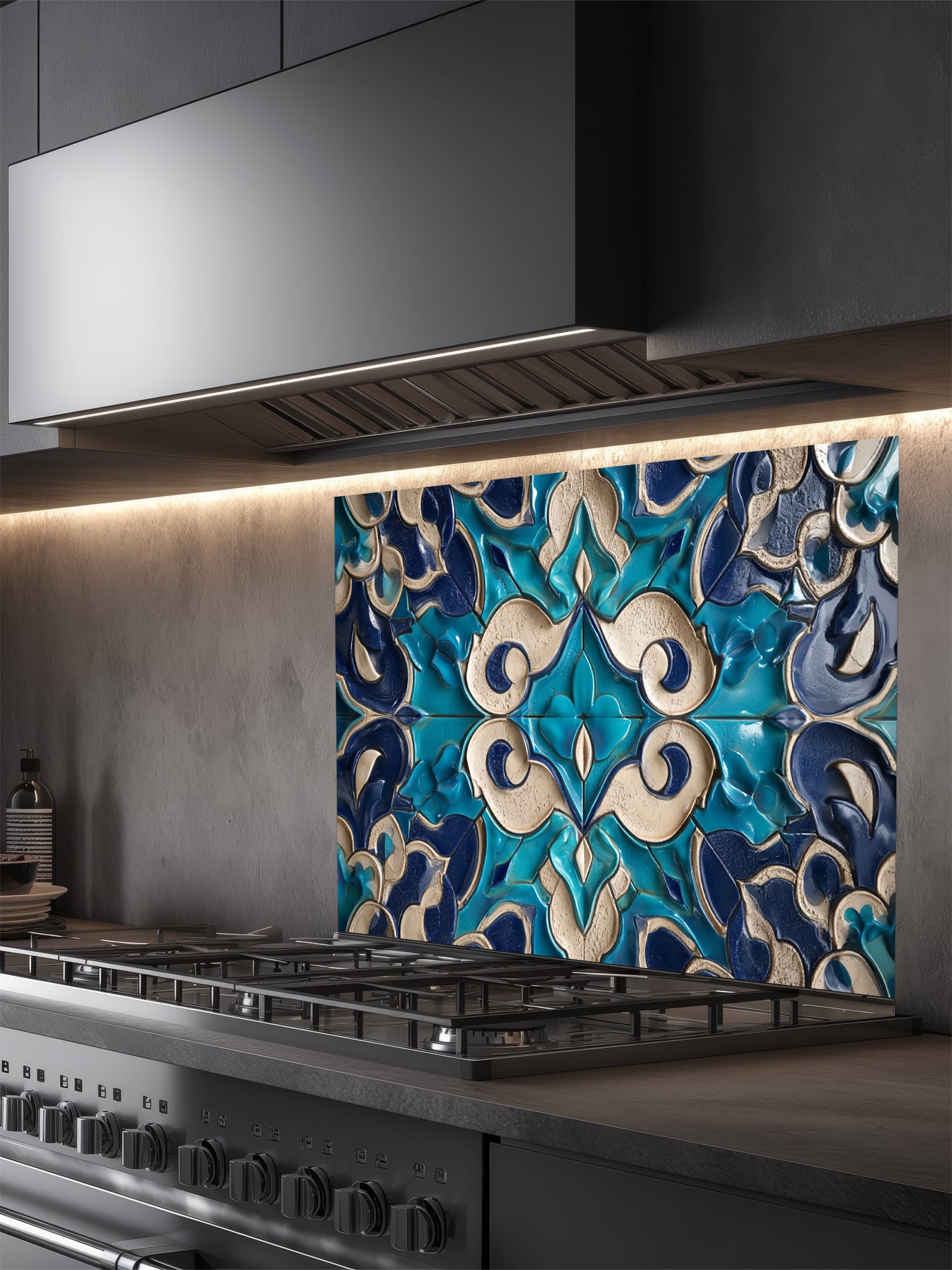 Stainless steel range hood with decorative blue and white tile backsplash in a kitchen.
