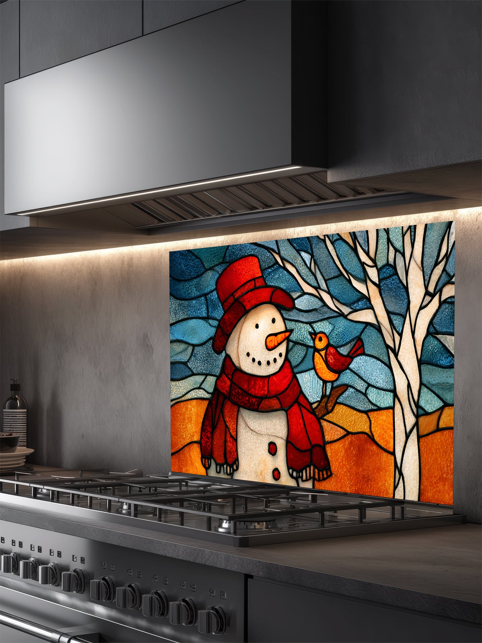 Tempered glass kitchen backsplash featuring a highly realistic 3D illusion of stained glass art showing a cheerful snowman in a red hat and a cute little bird perched on a winter tree against a frosty blue and amber background, installed behind a modern black stove.