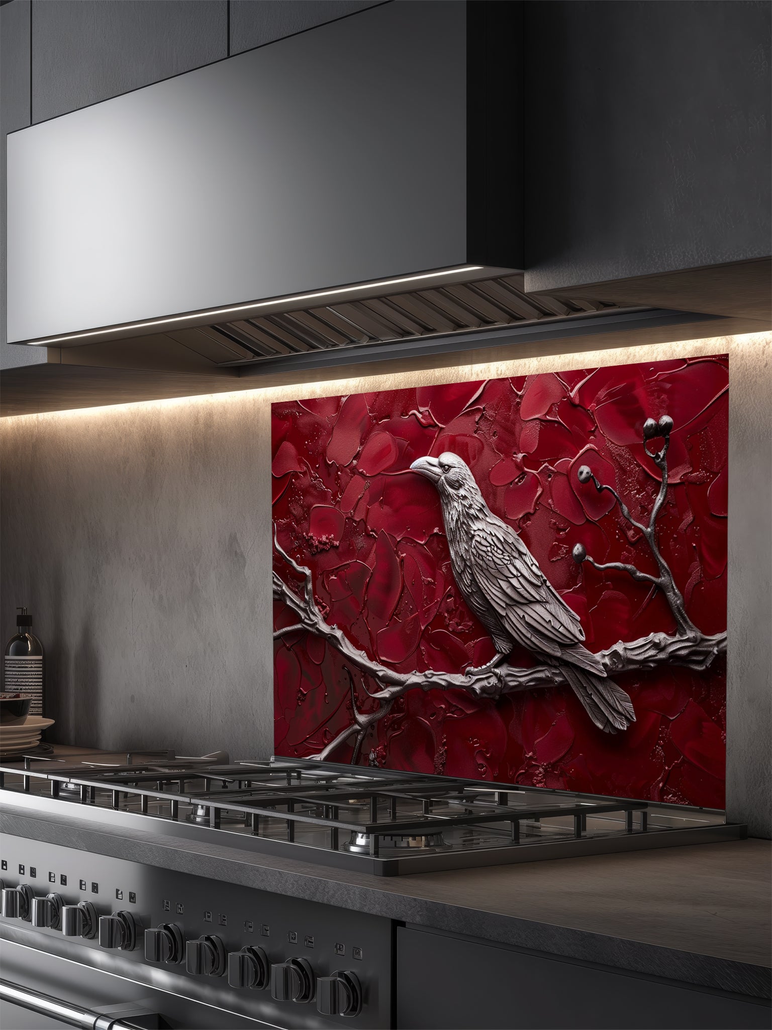Tempered glass kitchen backsplash featuring a highly realistic 3D illusion of a sculpted metallic raven perched on a branch with berries against a heavily textured, thick impasto crimson red background, installed behind a modern black stove.