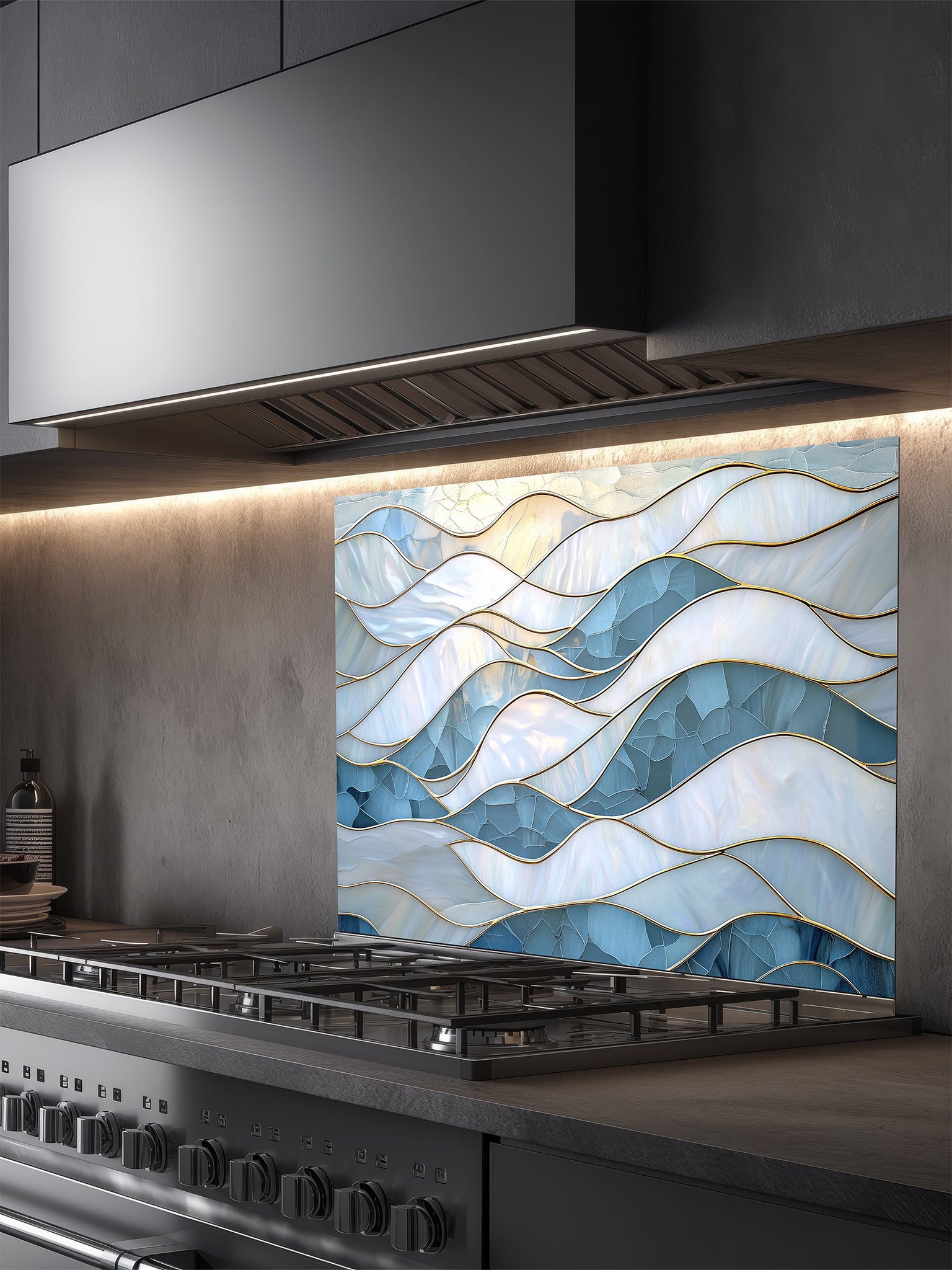 Tempered glass kitchen backsplash featuring a serene faux stained glass design of layered, flowing waves in icy blue and pearlescent white, separated by elegant gold outlines, installed behind a modern stainless steel stove.