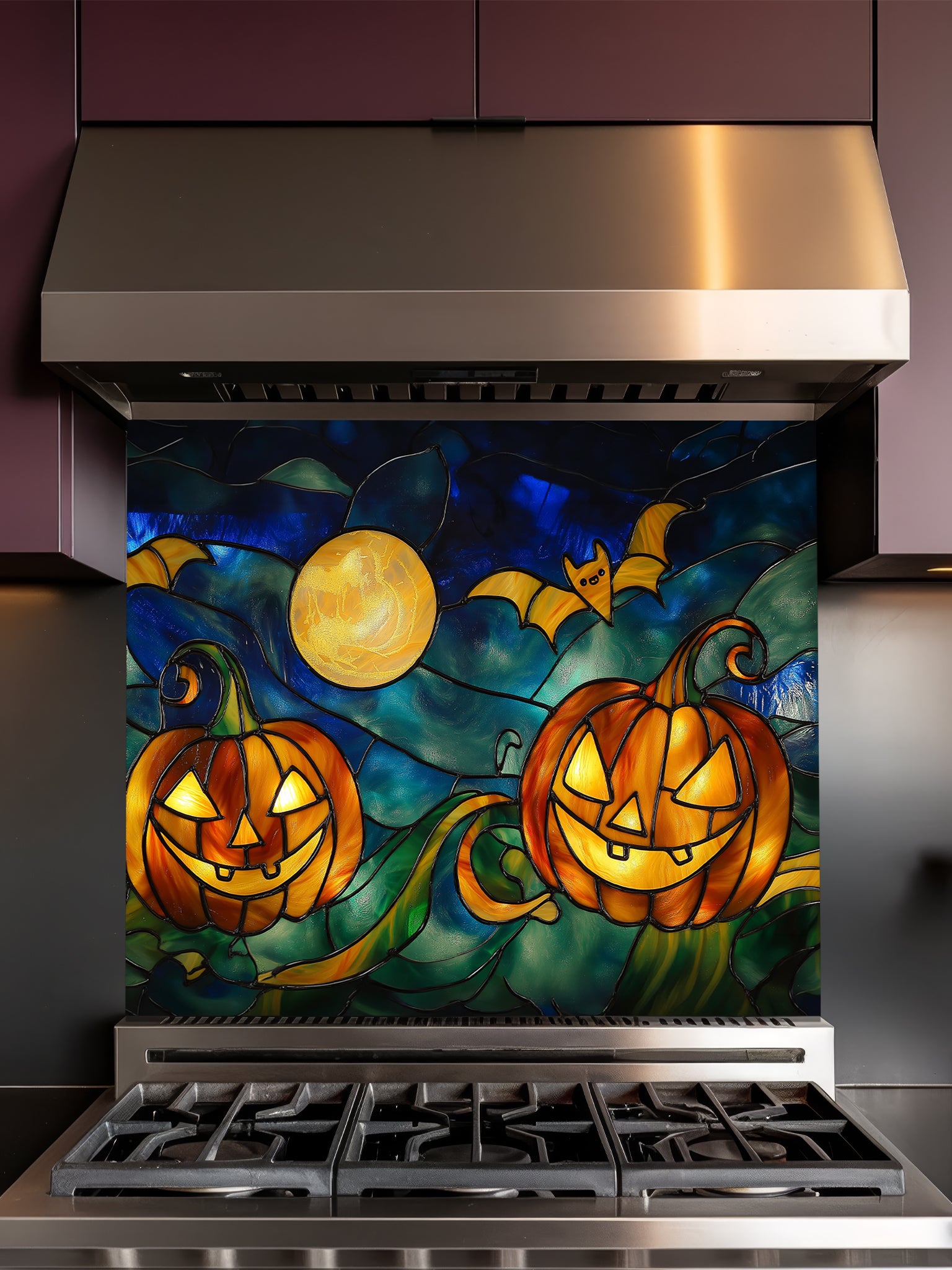 Stainless steel range hood with a decorative glass panel featuring pumpkins and bats.