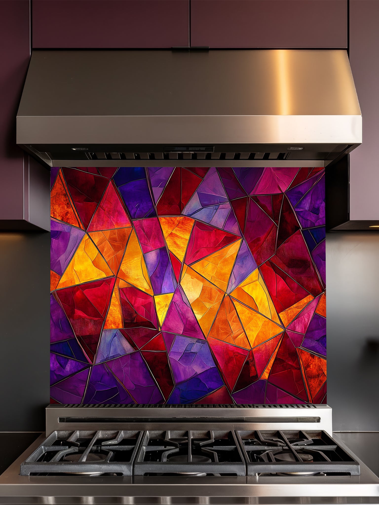 Tempered glass kitchen backsplash featuring a highly realistic illusion of abstract geometric stained glass with asymmetrical shards in vibrant, warm jewel tones of ruby red, magenta, amethyst, and amber, installed behind a modern black stove.