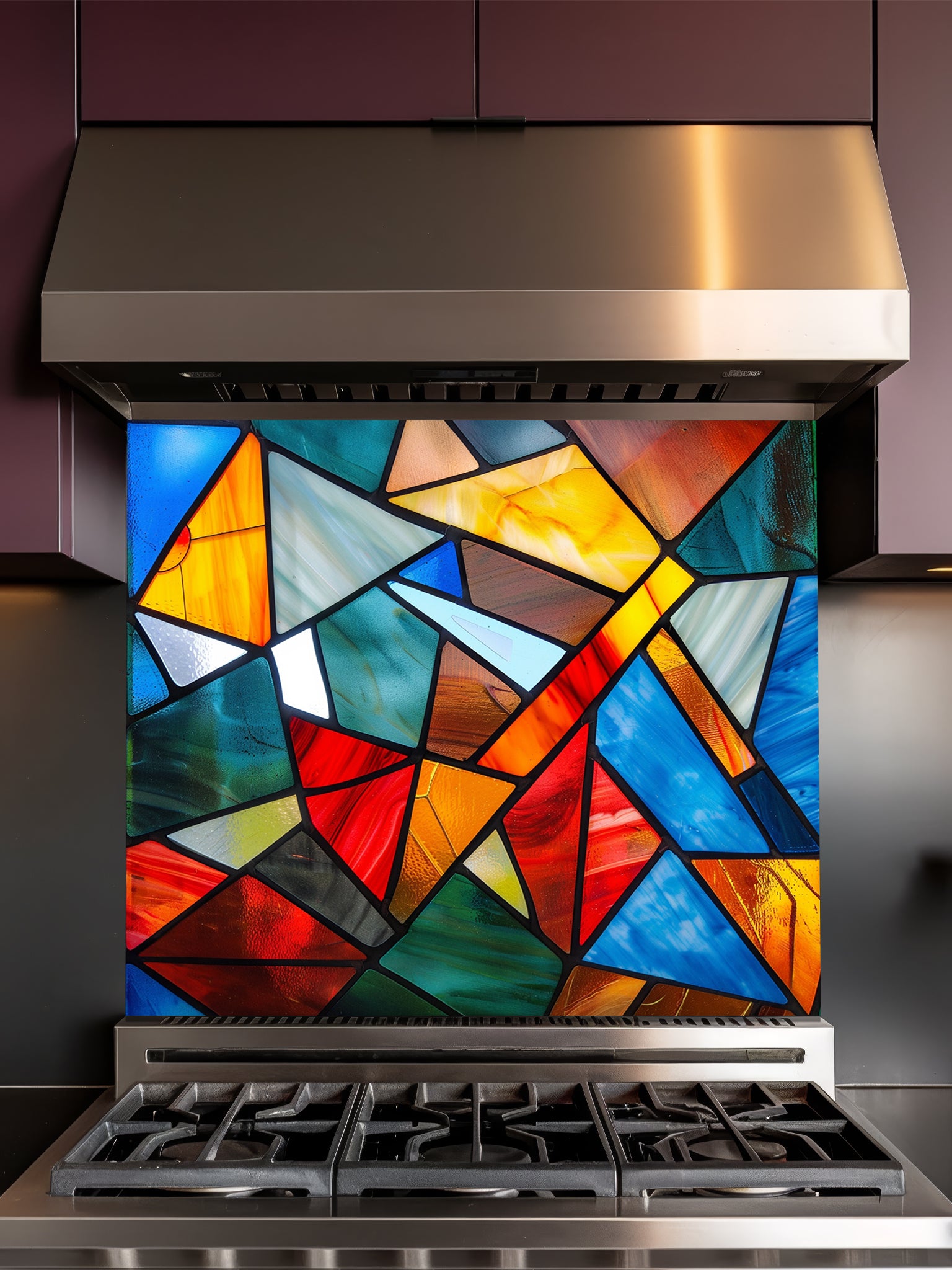 Tempered glass kitchen backsplash featuring a highly realistic illusion of abstract geometric stained glass with asymmetrical shards in vibrant, luminous shades of red, blue, yellow, and teal outlined by dark faux lead lines, installed behind a modern black stove.
