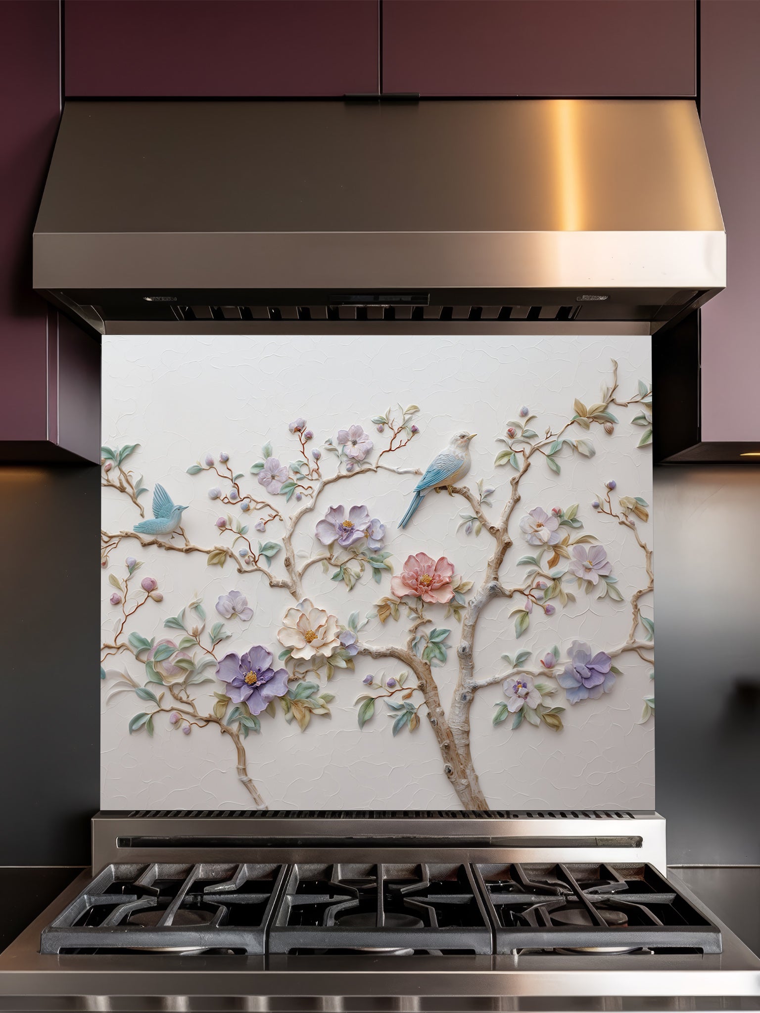 Tempered glass kitchen backsplash featuring a highly realistic 3D illusion of bas-relief plaster art with pastel blooming flowers and light blue birds perched on branches against a white textured background, installed behind a modern stainless steel stove.