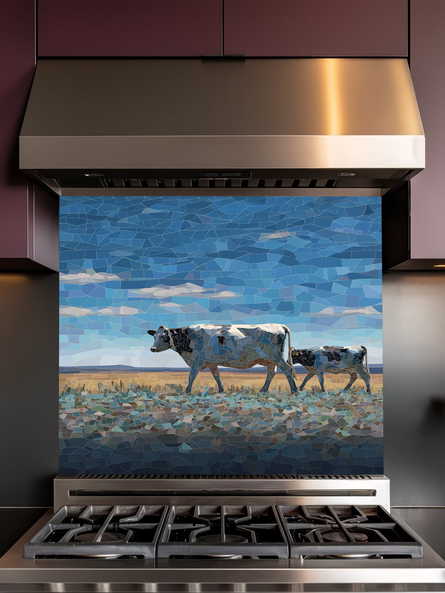 Faux mosaic tile art of a cow and calf in a pasture under a blue sky, UV printed on a smooth tempered glass kitchen backsplash, installed behind a modern stove.