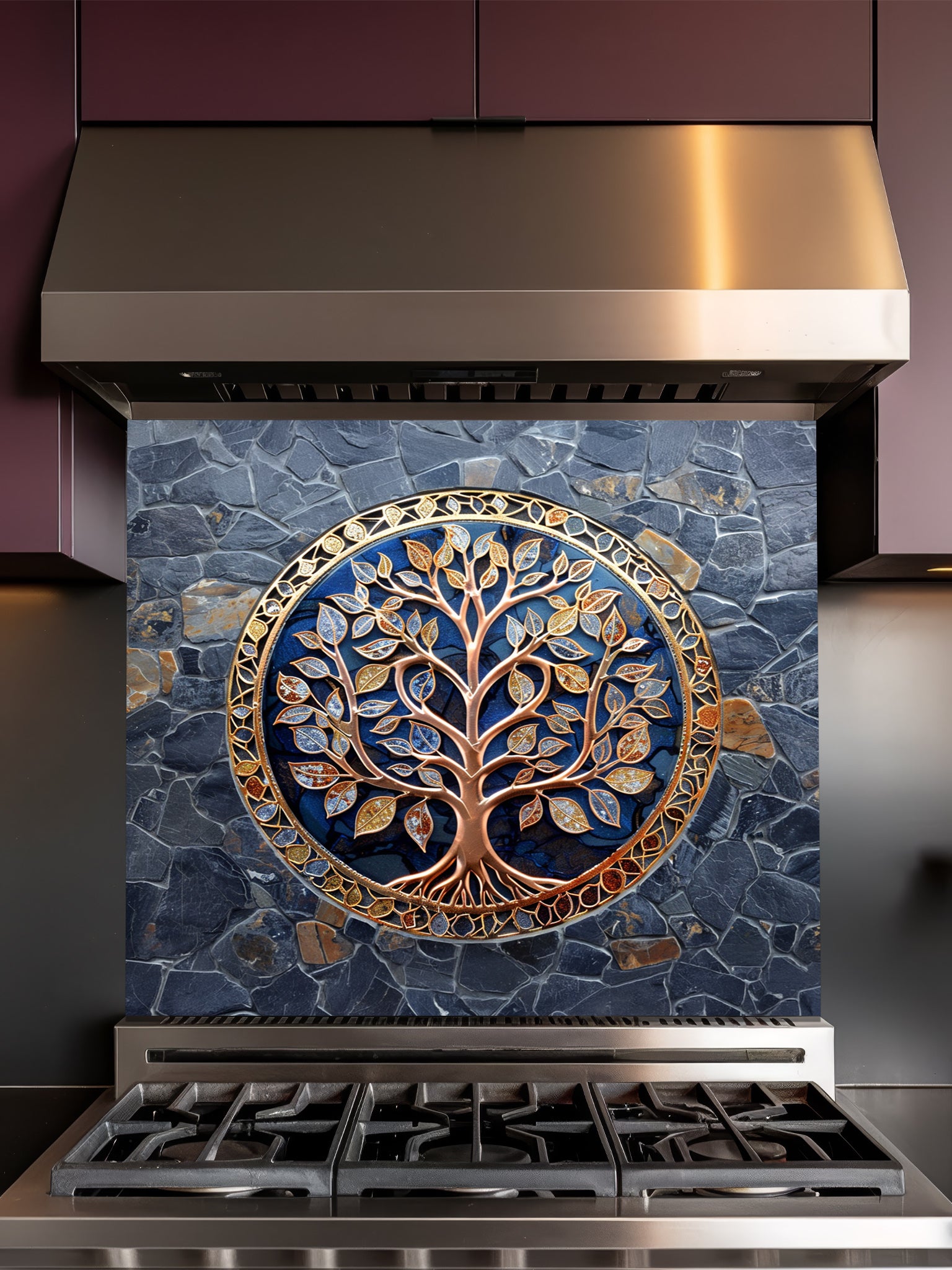 Stainless steel range hood with decorative mosaic glass backsplash featuring a tree of life design on a blue stone background.