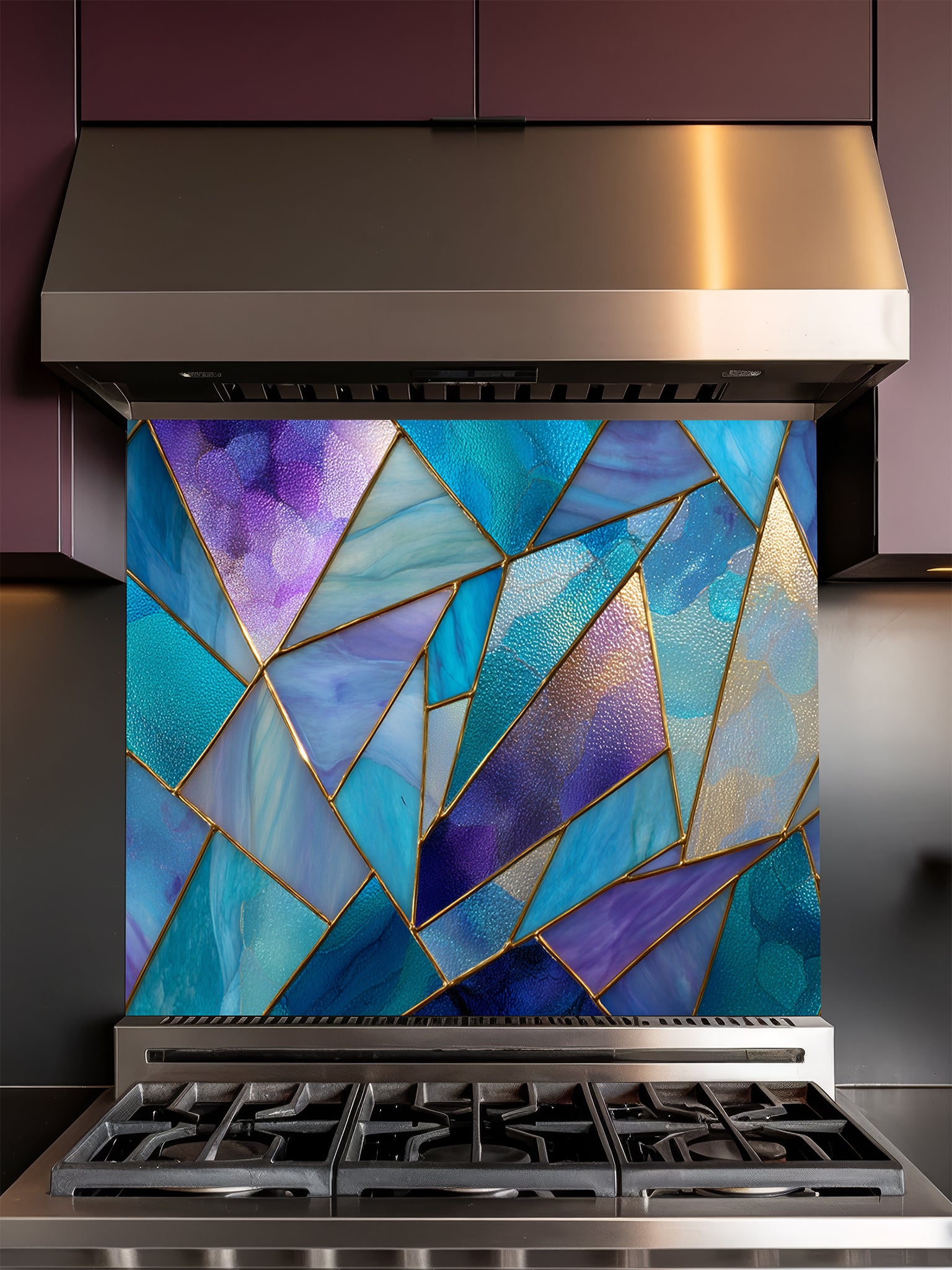 Tempered glass kitchen backsplash featuring a vibrant geometric stained glass effect with blue, teal, and purple shards separated by gold lines, installed behind a modern stainless steel stove.