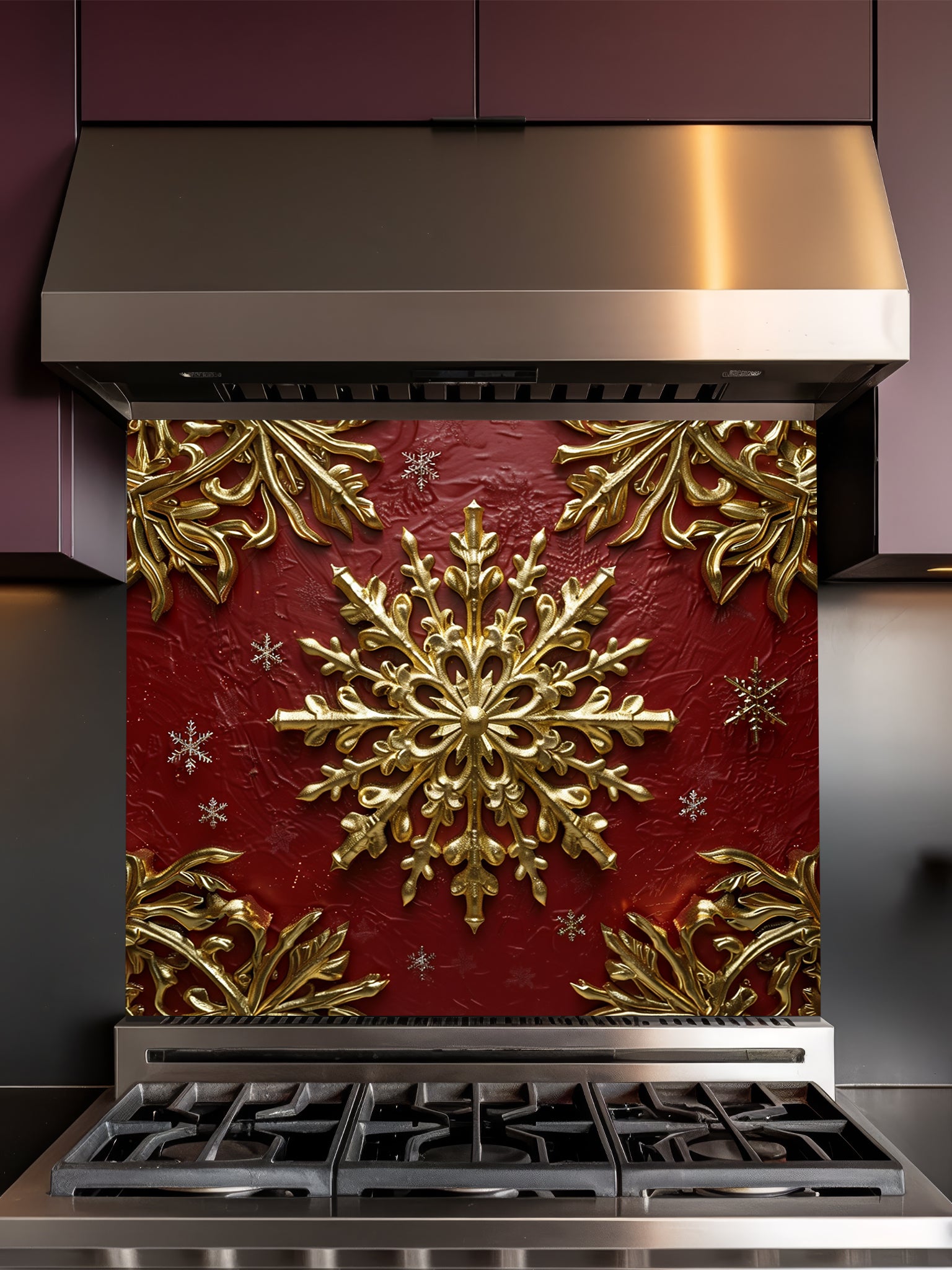 Tempered glass kitchen backsplash featuring a highly realistic 3D illusion of an ornate, embossed gold snowflake surrounded by smaller snowflakes and elegant golden corner flourishes against a rich, textured burgundy red background, installed behind a modern black stove.