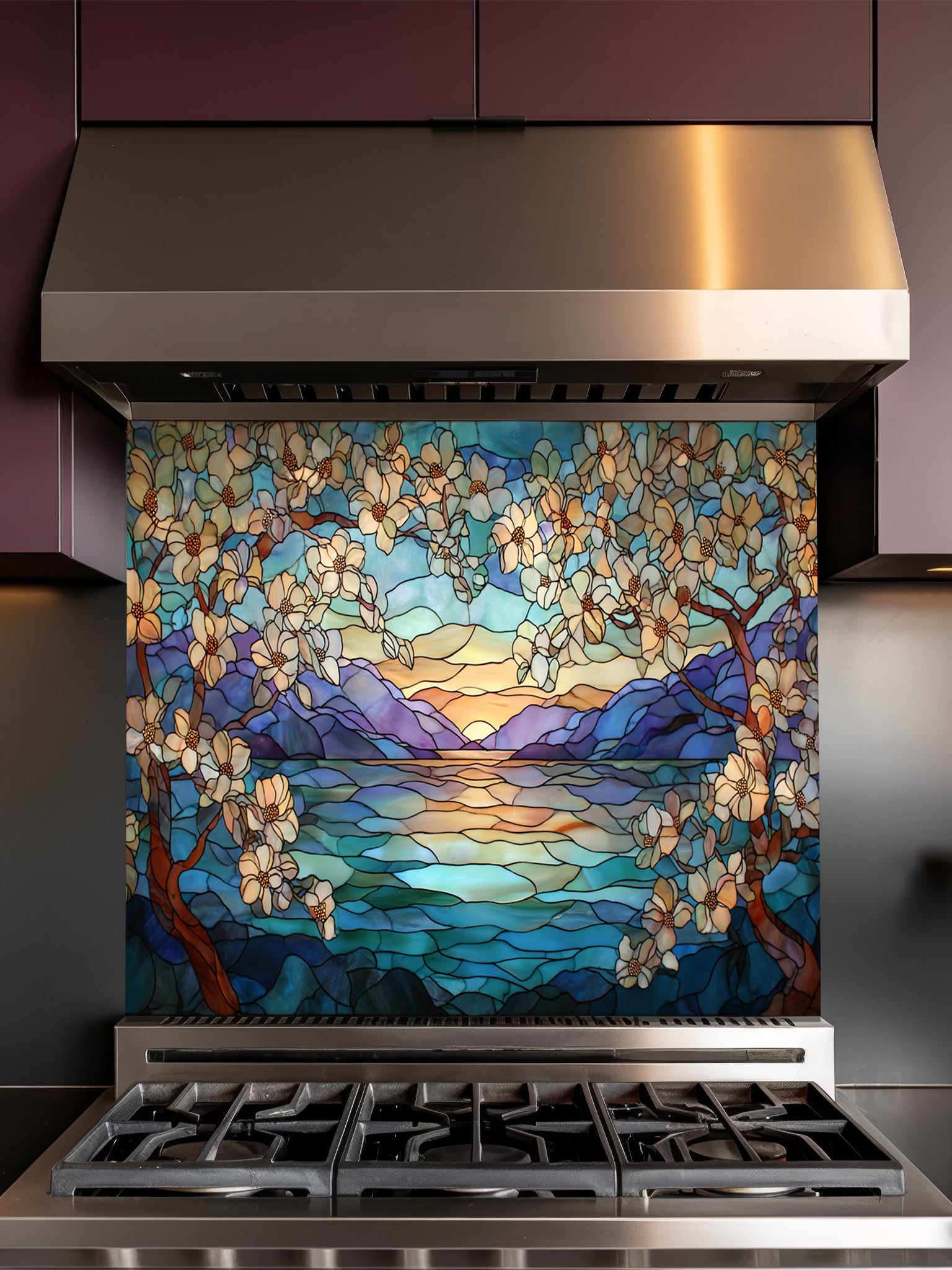 Stainless steel range hood with a decorative glass panel featuring a sunset over water and cherry blossoms.