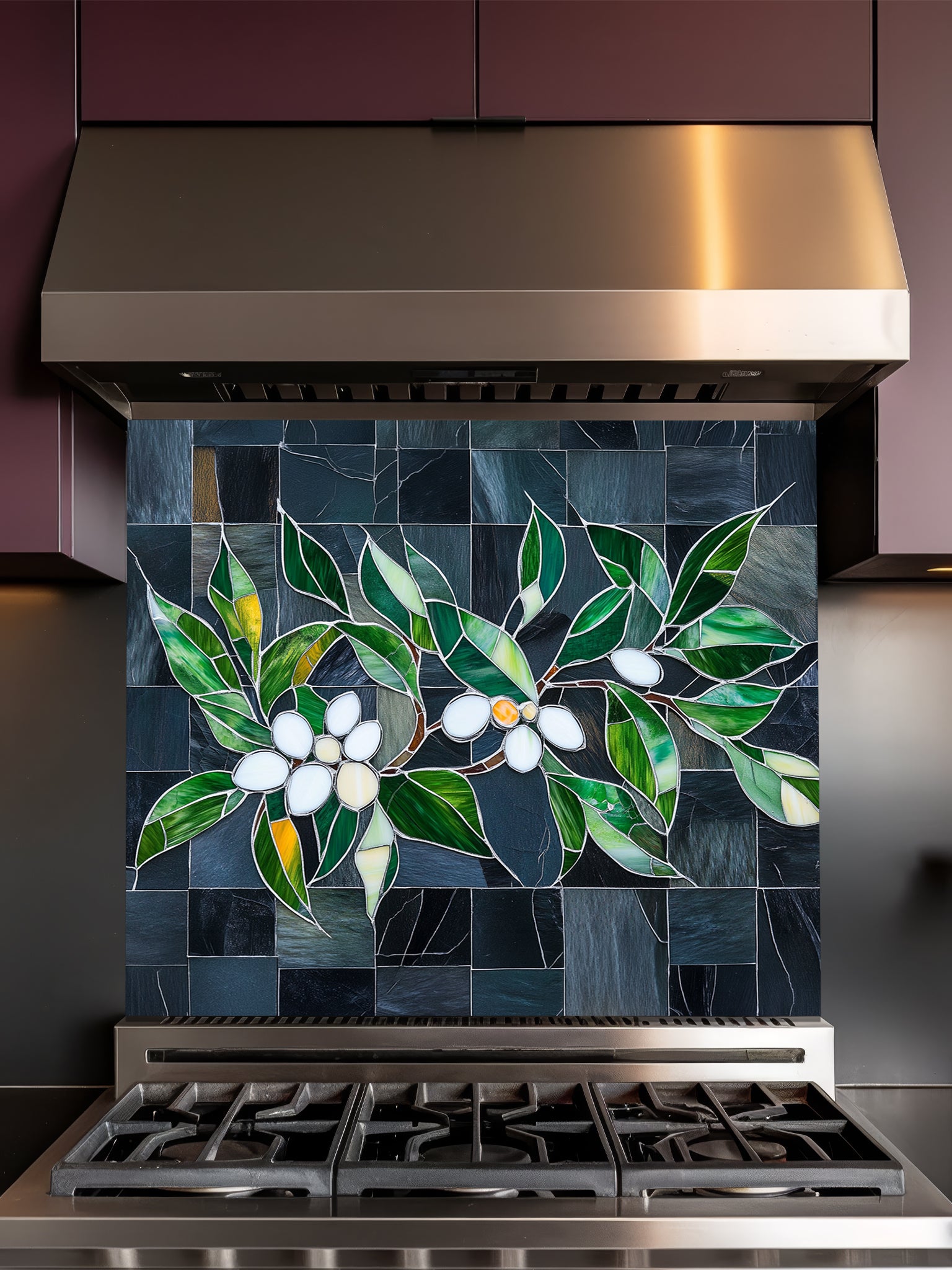 Tempered glass kitchen backsplash featuring a highly realistic 3D illusion of stained glass white blossoms and emerald green leaves integrated into a background of dark charcoal grey textured slate tiles, installed behind a modern black stove.