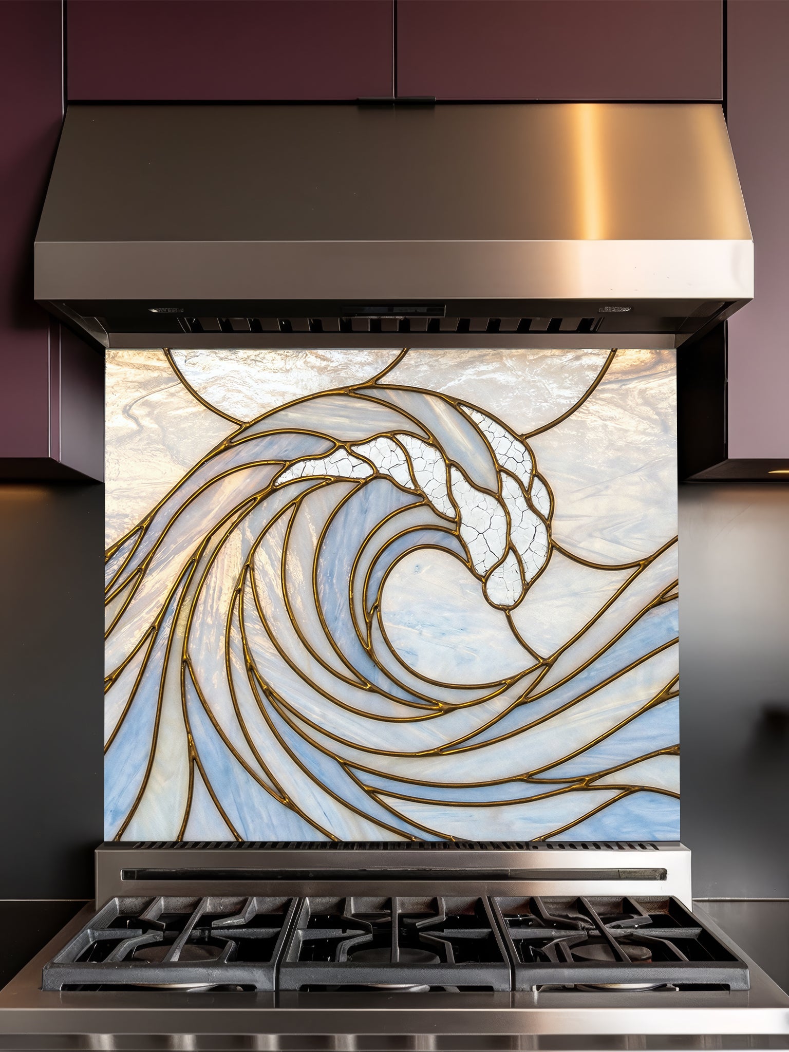 Stainless steel range hood with decorative glass panel featuring a wave design in a kitchen setting.