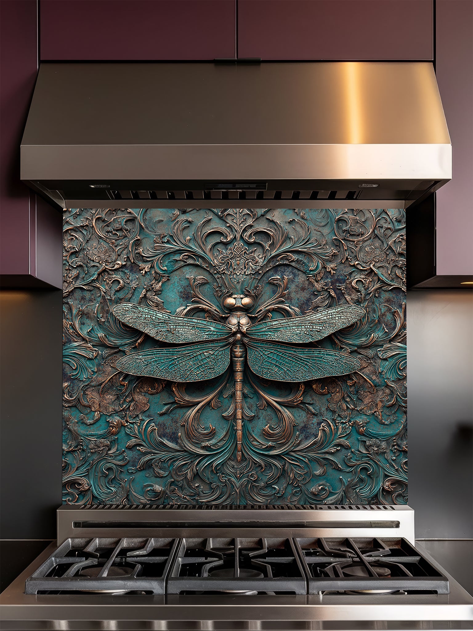 Tempered glass kitchen backsplash featuring a highly realistic 3D faux metal relief design of a detailed dragonfly and ornate antique bronze baroque scrollwork over a textured oxidized teal background, installed behind a modern stainless steel stove.