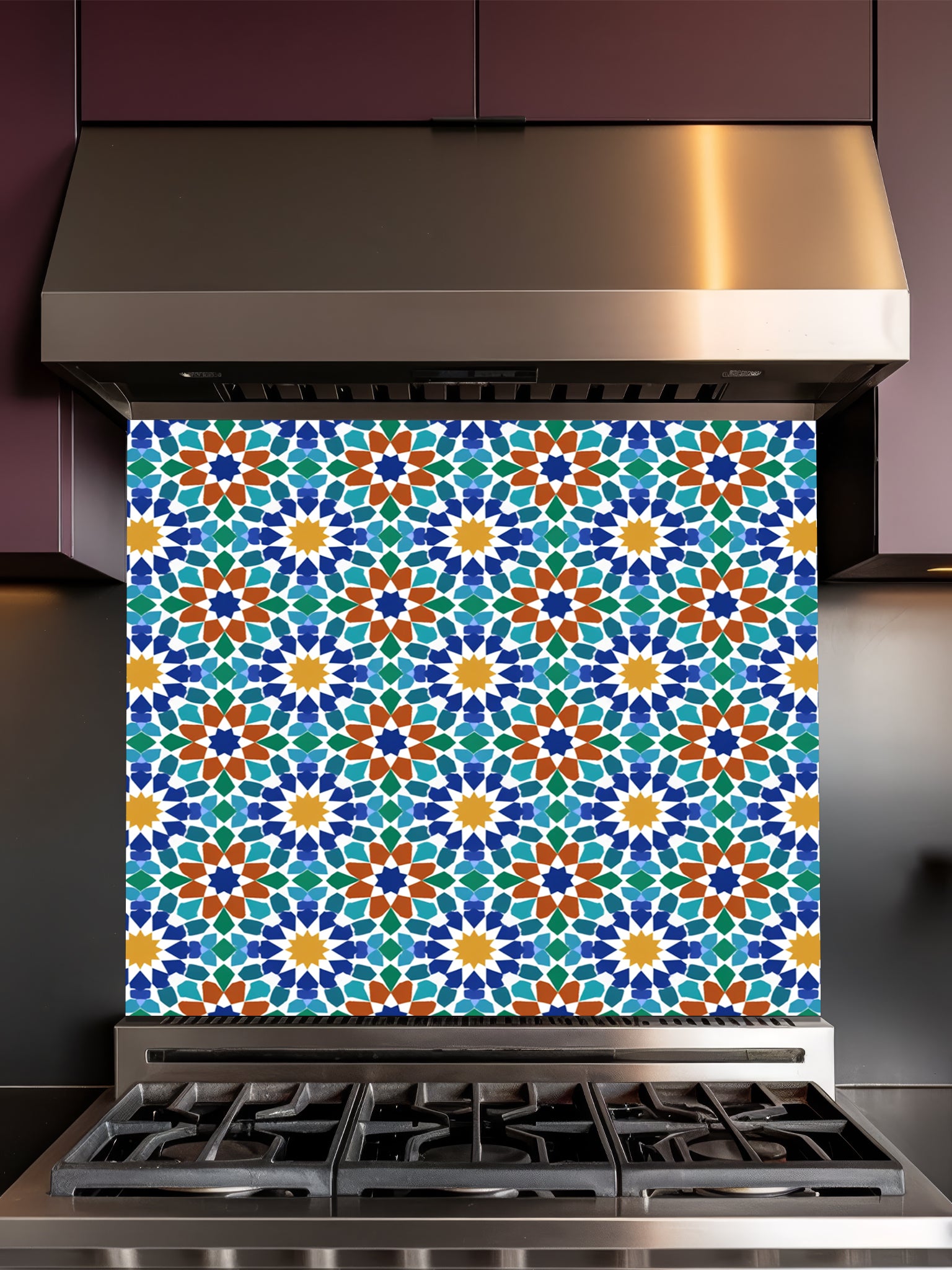 Stainless steel range hood with a colorful geometric patterned backsplash