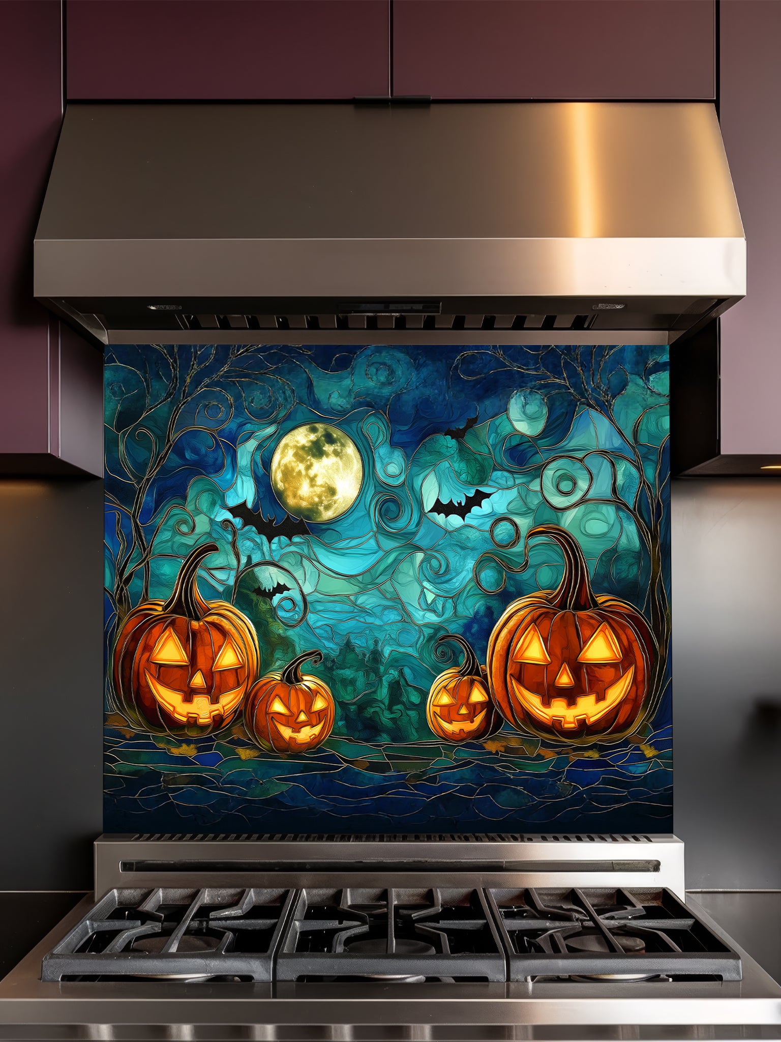 A festive kitchen featuring a tempered glass backsplash with a spooky stained glass effect illustration showing glowing Halloween pumpkins, bats, and a full moon, installed behind a metallic gray stove.