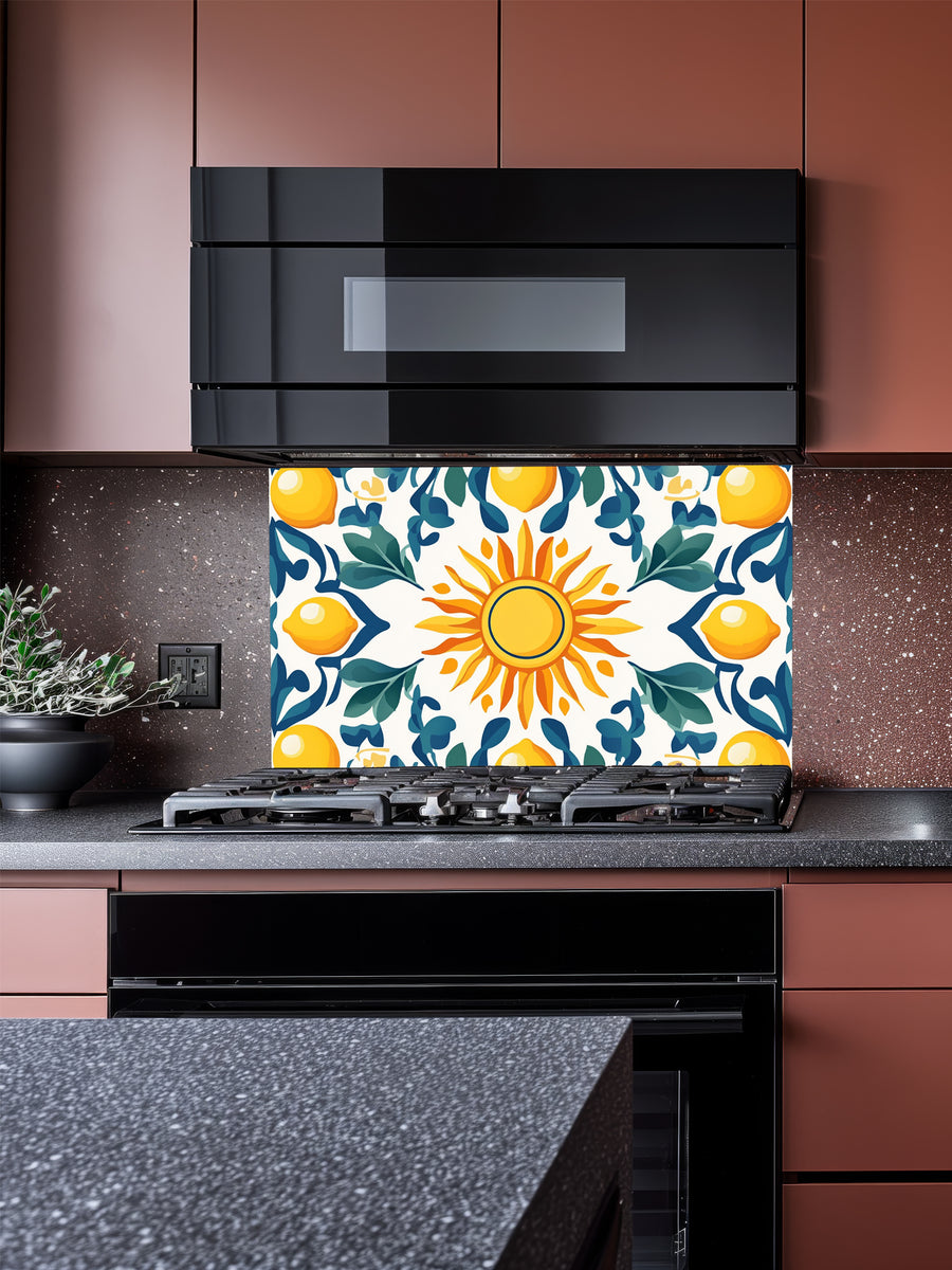 Vibrant Mediterranean Majolica style tile pattern featuring a central sun, yellow lemons, and teal leaves, UV printed on a smooth tempered glass kitchen backsplash.