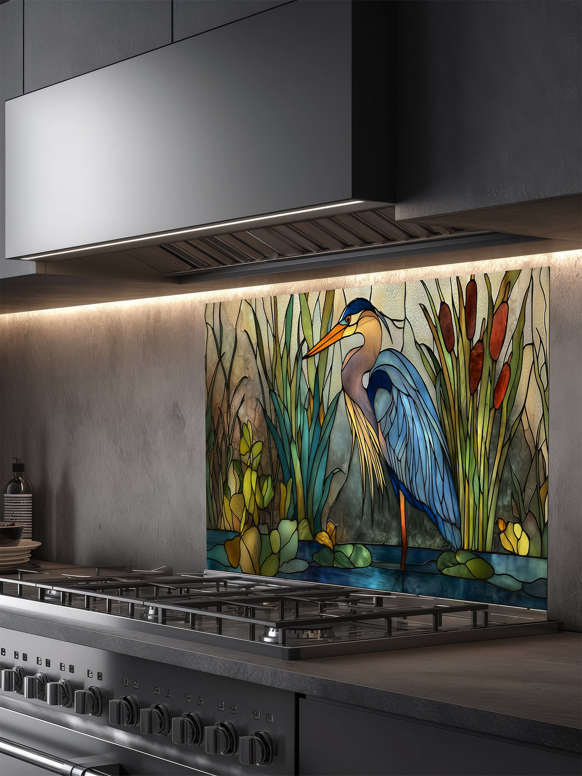 Tempered glass kitchen backsplash featuring a serene faux stained glass design of a majestic blue heron standing in a wetland with cattails and lily pads, installed behind a modern stainless steel stove.