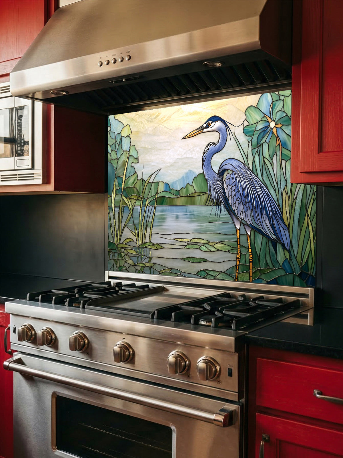 Tempered glass kitchen backsplash featuring a bright faux stained glass design of a majestic blue heron standing among lily pads against a glowing sunrise and mountain landscape, installed behind a modern stainless steel stove.
