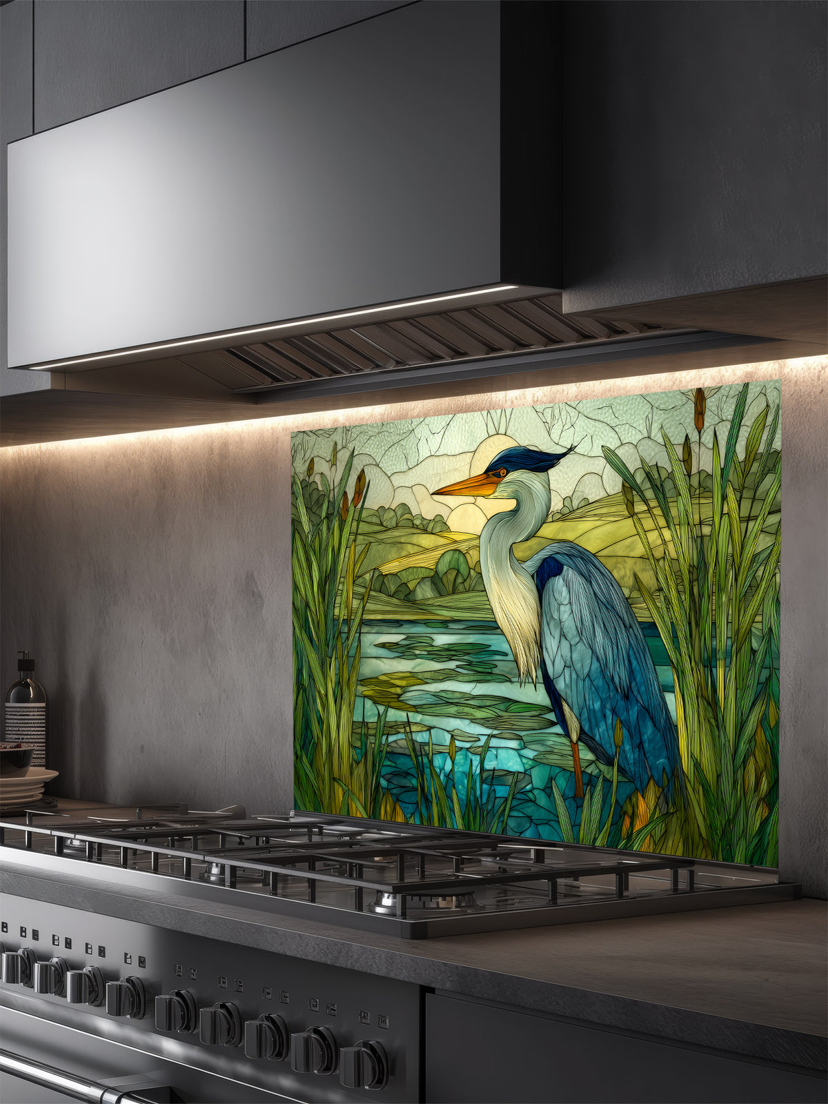 Tempered glass kitchen backsplash featuring a highly realistic 3D illusion of stained glass art showing a majestic blue heron standing in a serene wetland marsh with green cattails and a tranquil lake, installed behind a modern stainless steel stove.