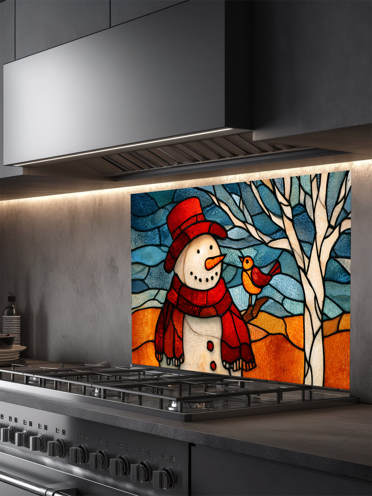 Tempered glass kitchen backsplash featuring a highly realistic 3D illusion of stained glass art showing a cheerful snowman in a red hat and a cute little bird perched on a winter tree against a frosty blue and amber background, installed behind a modern black stove.