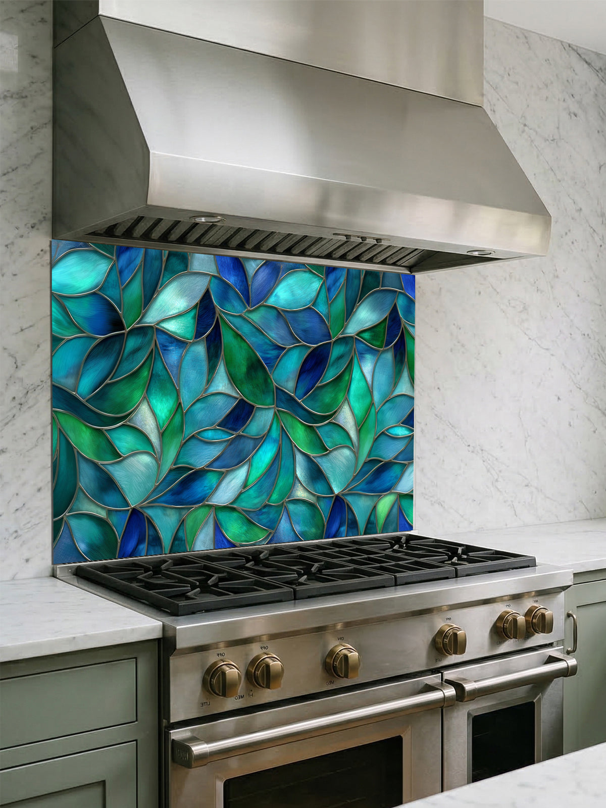 Tempered glass kitchen backsplash featuring a vibrant botanical stained glass effect with overlapping leaves in shades of teal, blue, and emerald green, installed behind a modern stainless steel stove.