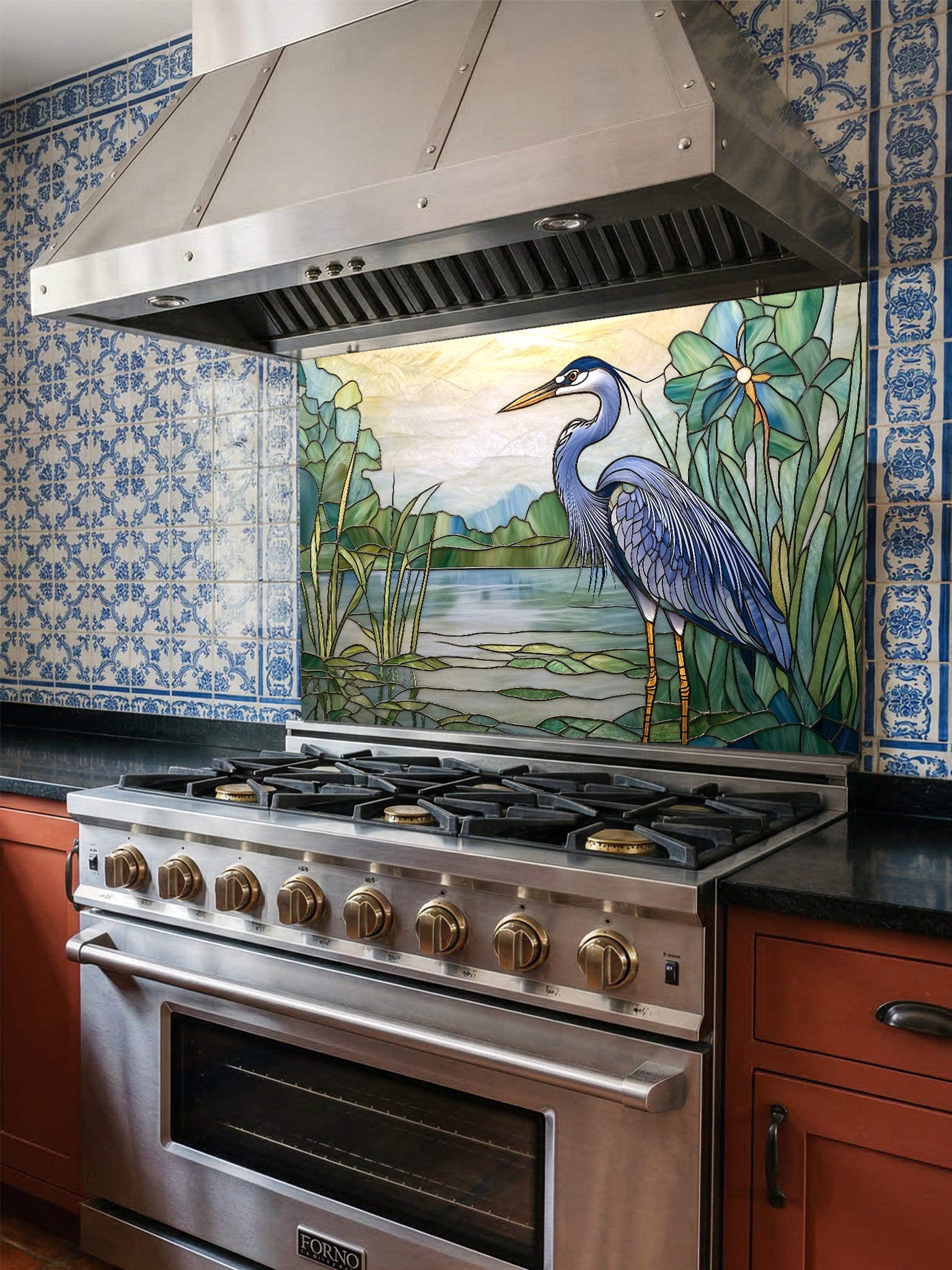 Tempered glass kitchen backsplash featuring a bright faux stained glass design of a majestic blue heron standing among lily pads against a glowing sunrise and mountain landscape, installed behind a modern stainless steel stove.