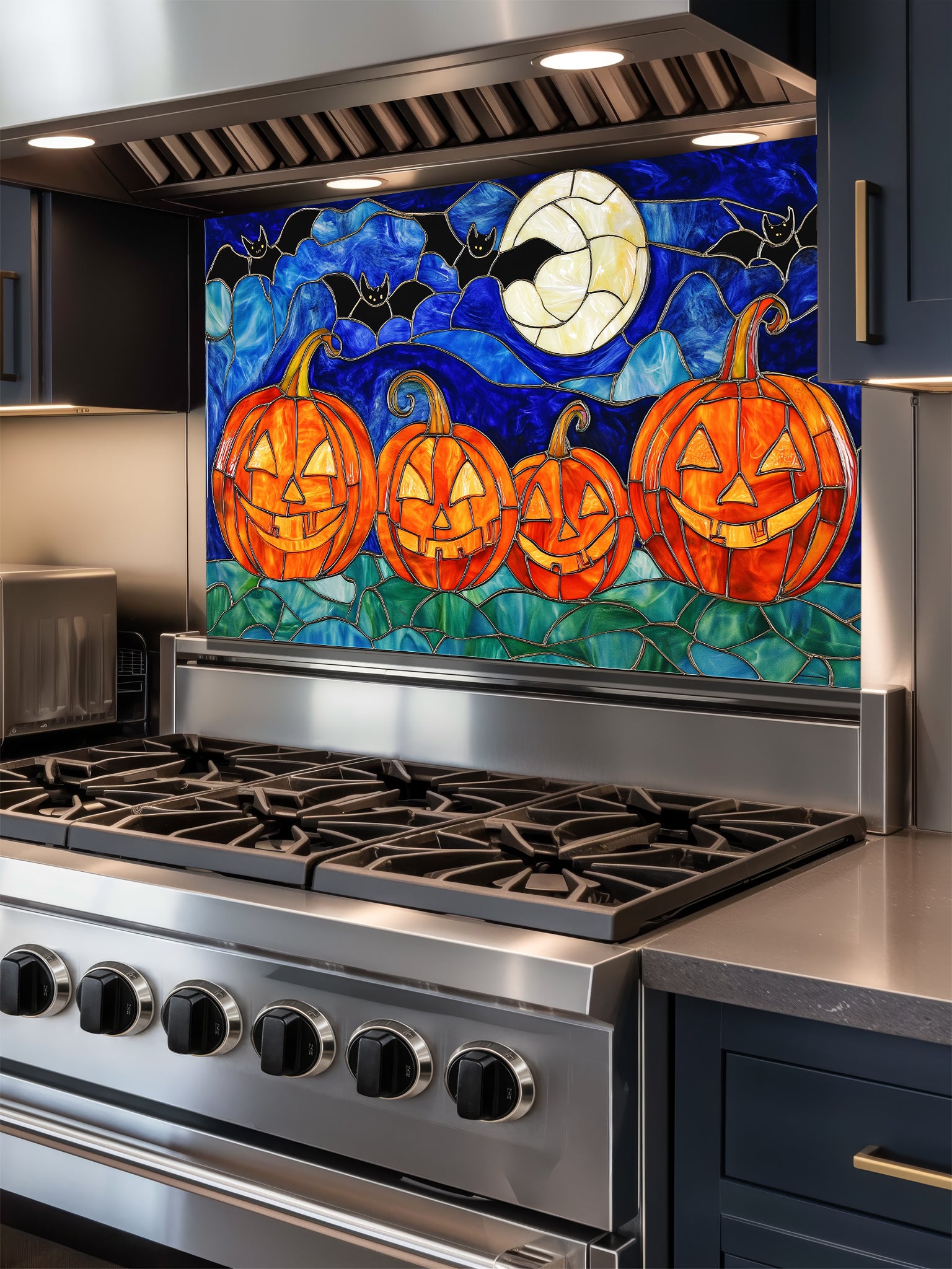 Stainless steel stove with a decorative backsplash featuring pumpkins and a moon.
