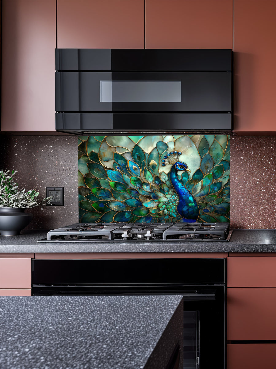 Tempered glass kitchen backsplash featuring a highly realistic 3D illusion of Art Nouveau stained glass showing a magnificent peacock with flowing teal, emerald, and sapphire feathers outlined in gold, installed behind a modern stainless steel stove.